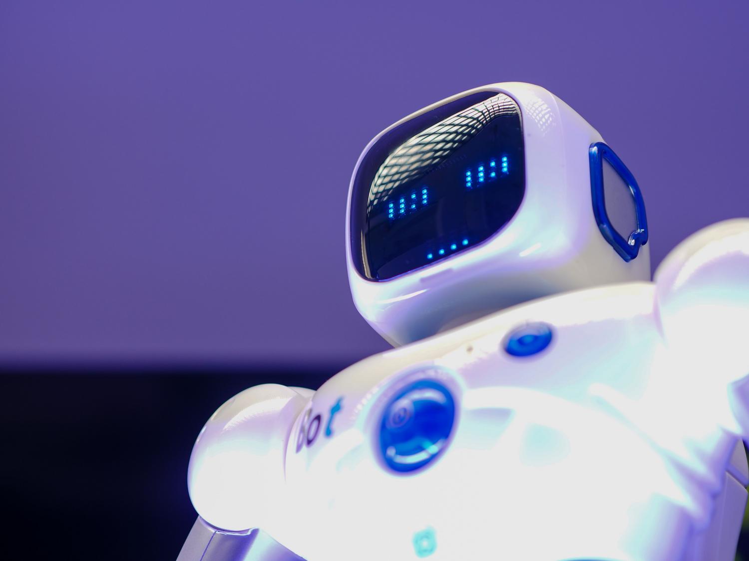 Robot humanoide moderno con rostro digital, representando la inteligencia artificial de vanguardia y su interacción con los seres humanos.
