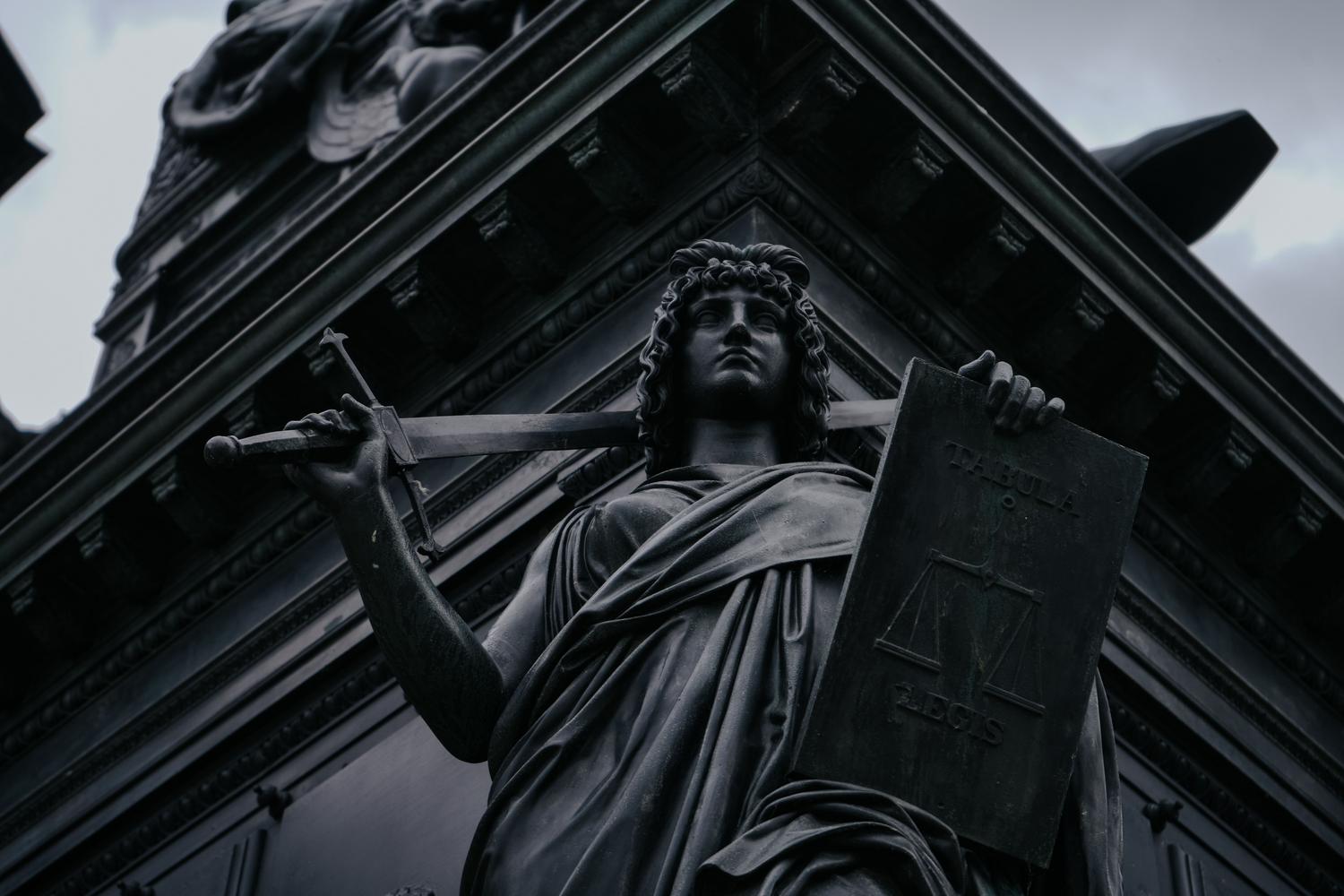 Estatua de la Justicia con la Tabula Legis, simbolizando el equilibrio entre la innovación tecnológica y la protección de los derechos fundamentales.