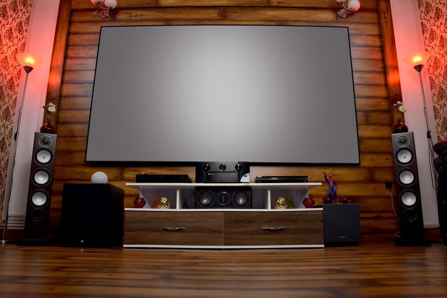 Sistema de audio y vídeo de alta gama en un salón elegante, ilustrando la optimización de un centro de entretenimiento AV.