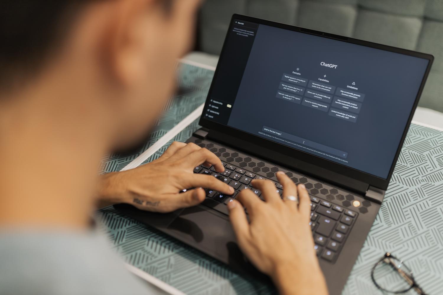 Persona trabajando en un ordenador portátil utilizando una interfaz de chat de inteligencia artificial.