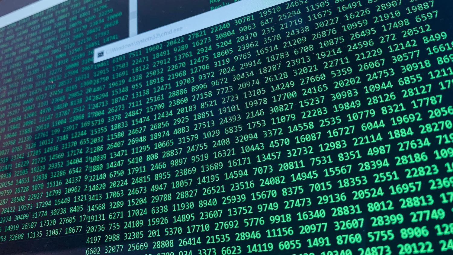 Pantalla de ordenador con código verde sobre fondo negro, ilustrando el proceso de cifrado de datos del ransomware.
