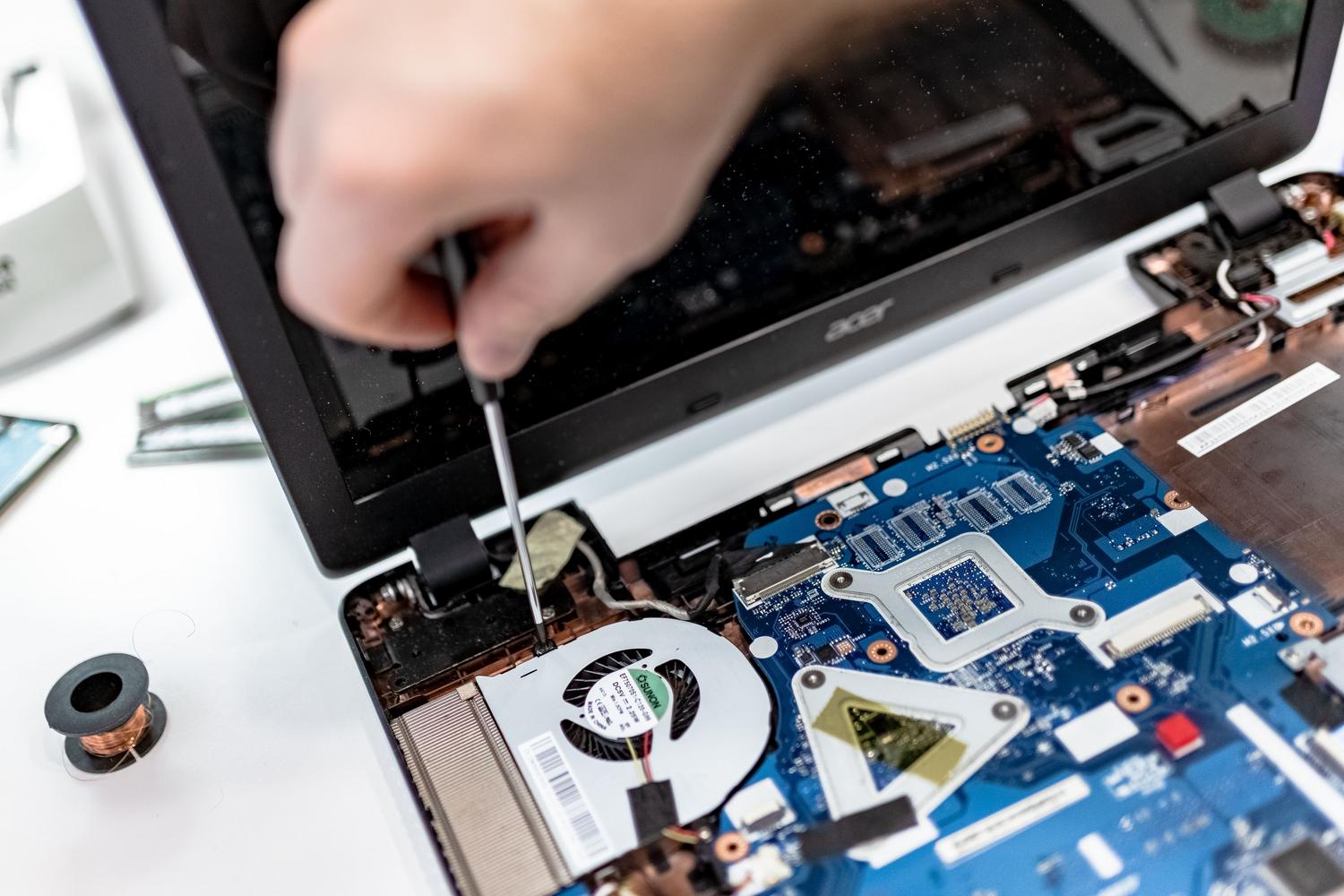 Primer plano de la reparación de la placa base de un ordenador portátil.
