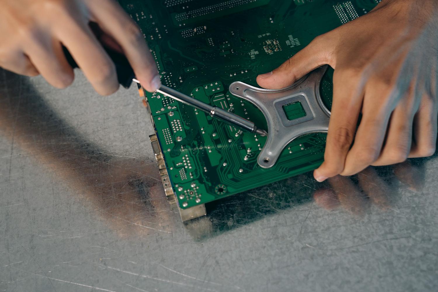 Ensamblaje manual de componentes de hardware en una placa de circuito impreso.