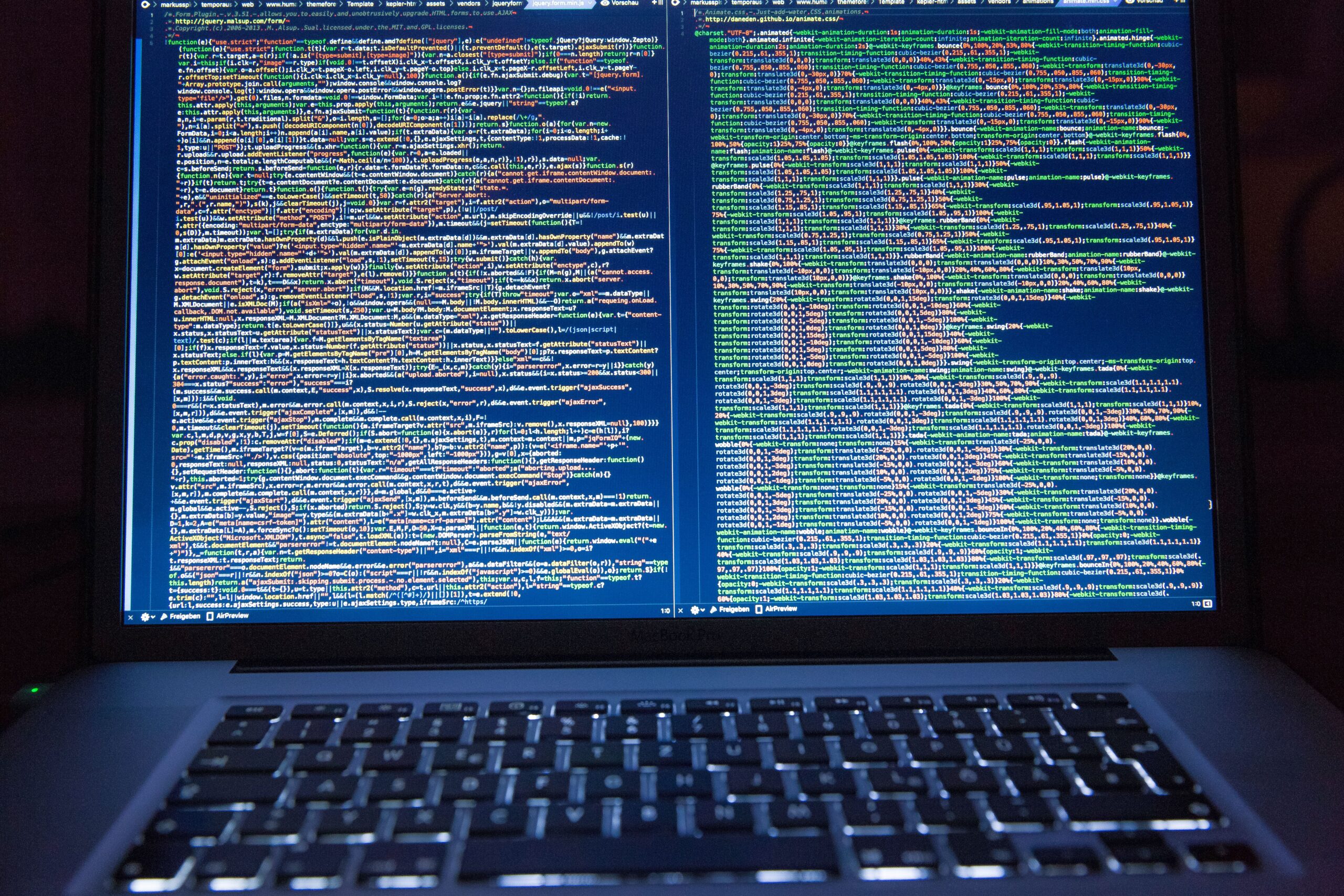 Primer plano de un ordenador portátil mostrando líneas de código de programación, simbolizando el desarrollo de software y el código fuente.