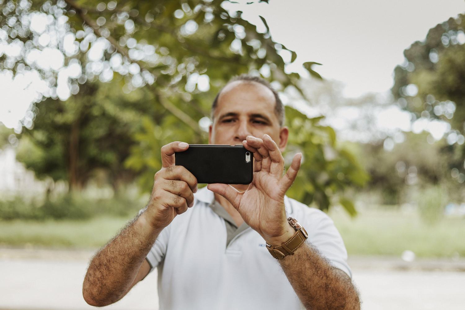 Persona capturando una fotografía con un smartphone en un entorno natural, representando la inmediatez de la fotografía móvil.