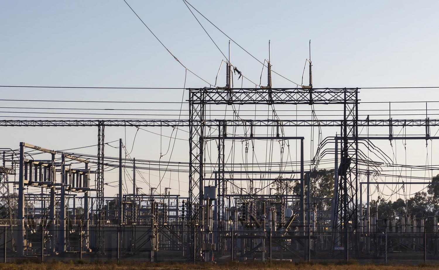 Subestación eléctrica de alta tensión con estructuras de acero y líneas eléctricas, ejemplificando el impacto de la reactancia en la industria energética.