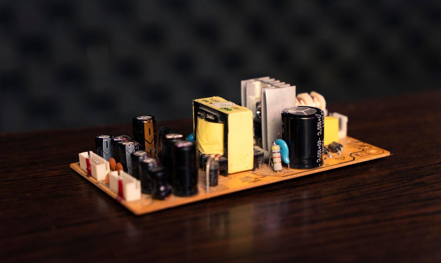 Placa de circuito electrónico con una variedad de componentes incluyendo condensadores, resistencias y transformadores, ideal para ilustrar la combinación de impedancia.