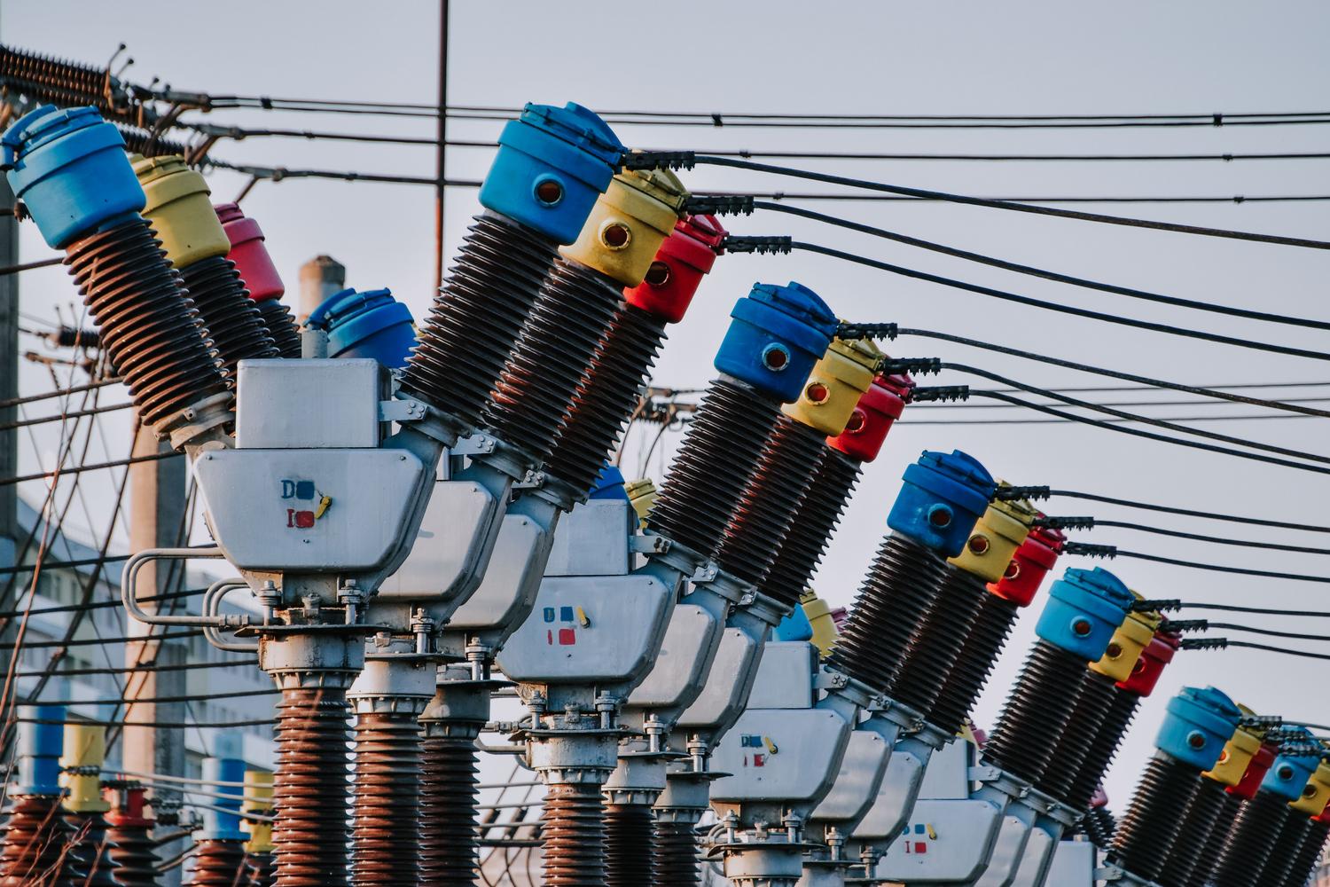 Primer plano de transformadores eléctricos en un entorno exterior, representando la inductancia a escala industrial.