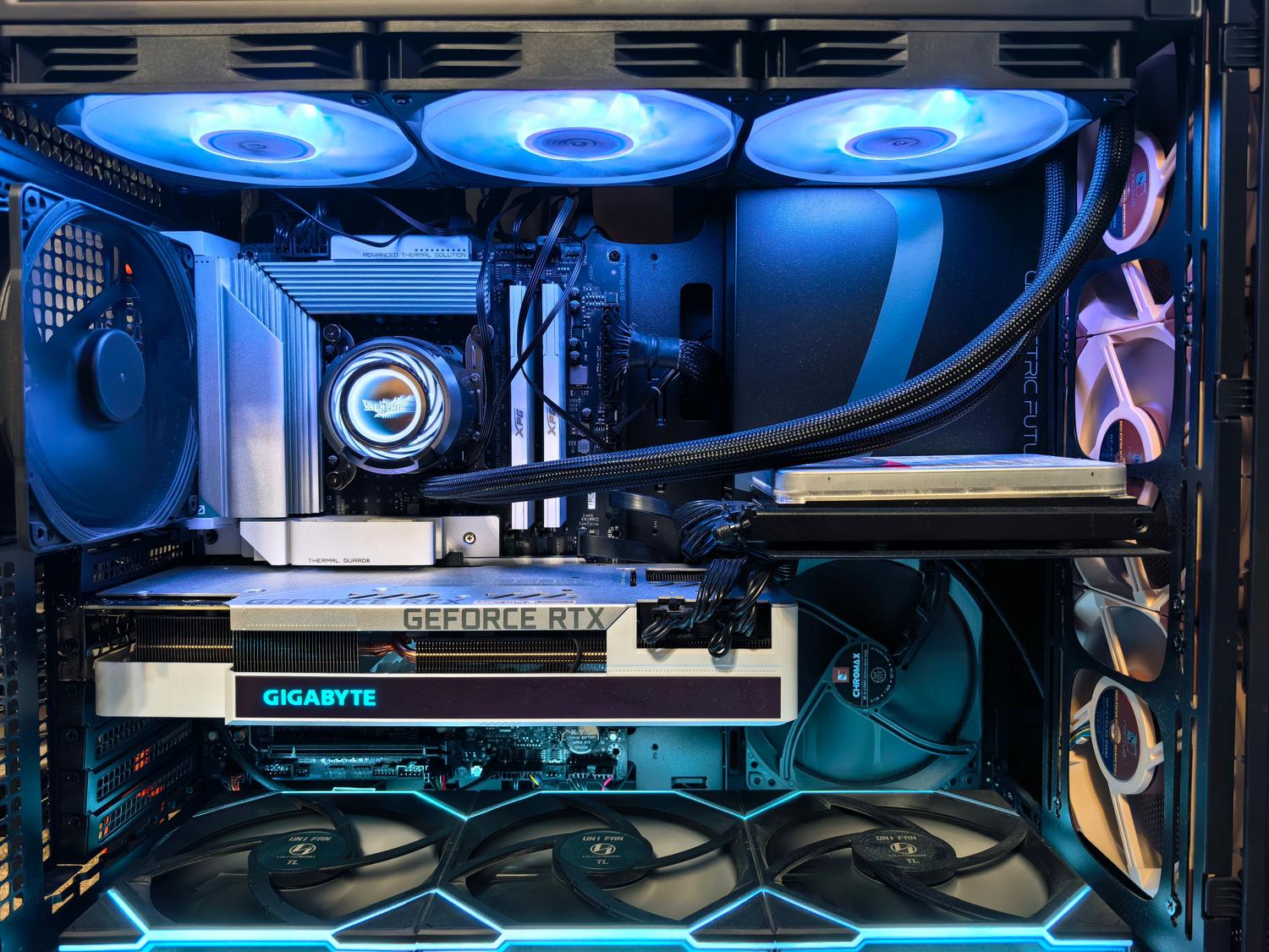Detalle interno de un PC gaming premium con refrigeración líquida y tarjeta gráfica NVIDIA GeForce RTX.