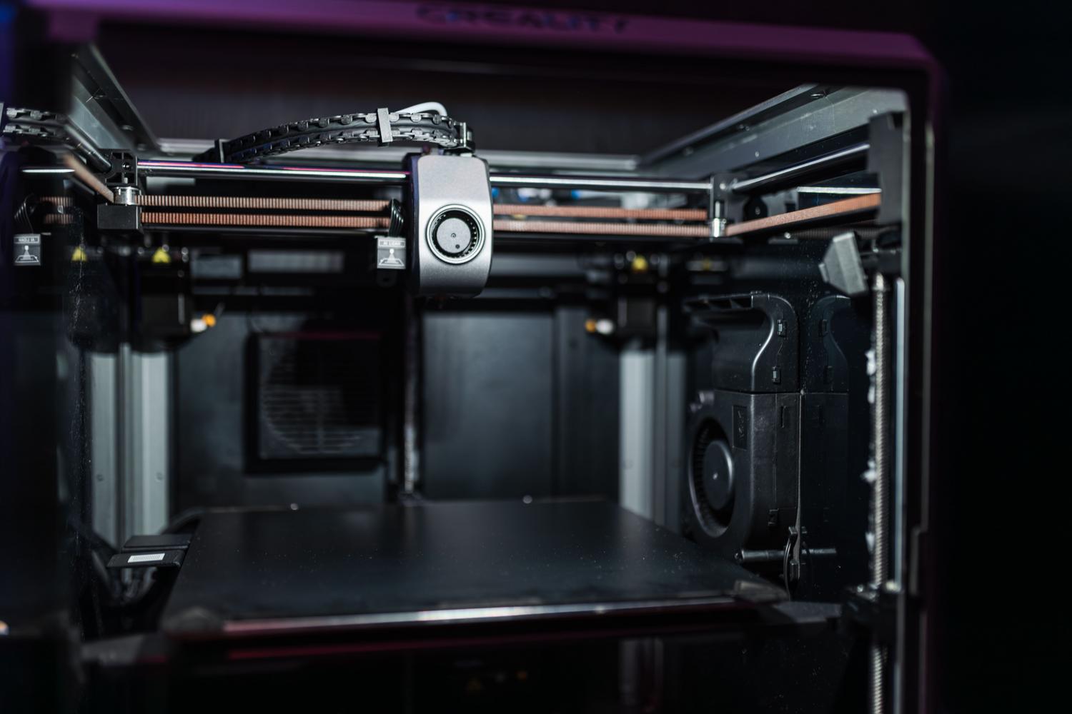 Vista interior de una impresora 3D moderna que muestra los componentes mecánicos y la tecnología de precisión.