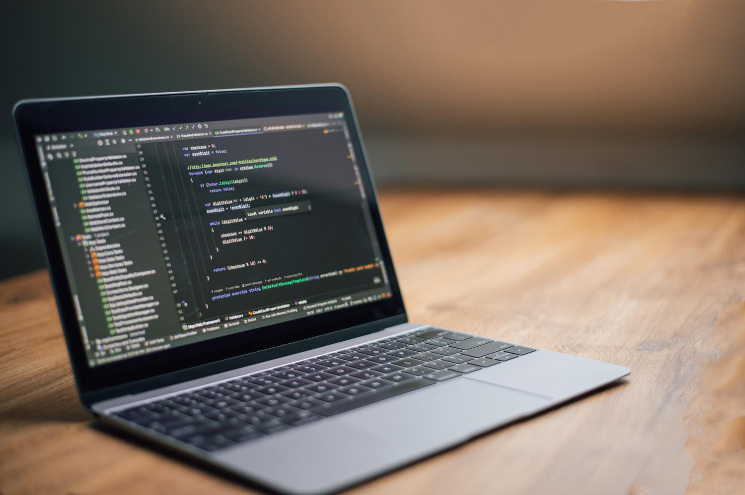 Laptop mostrando líneas de código de programación en pantalla, ideal para la sección de métodos avanzados y despliegue de apps.
