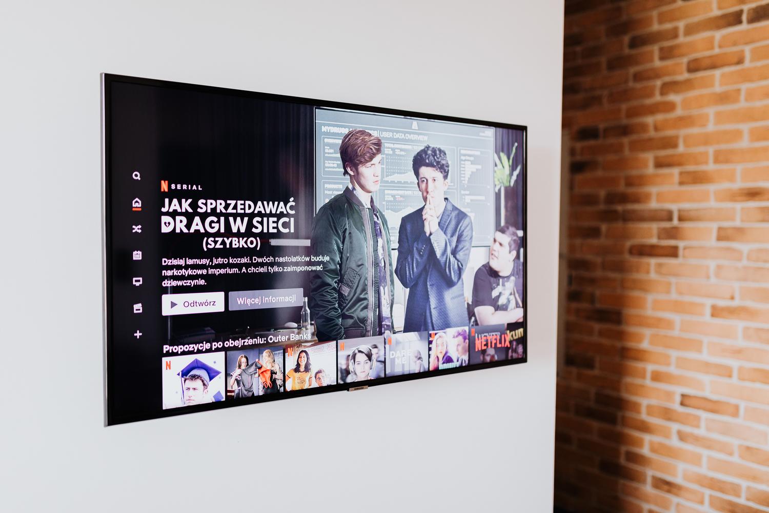 Televisor inteligente de pantalla plana montado en una pared blanca en un salón de diseño minimalista.