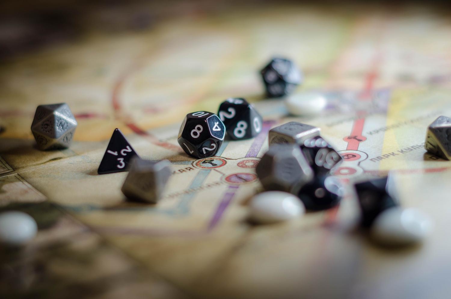 Dados de rol sobre un mapa estratégico, simbolizando el azar y la recompensa de las tareas opcionales en los RPG.