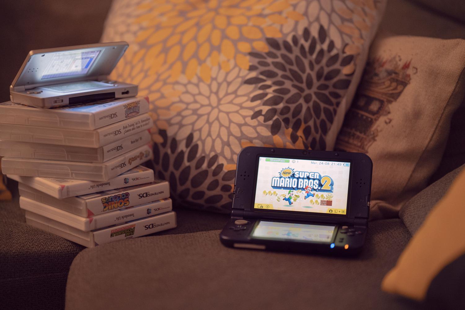 Consolas portátiles y cartuchos sobre un sofá, representando la versatilidad del gaming moderno.