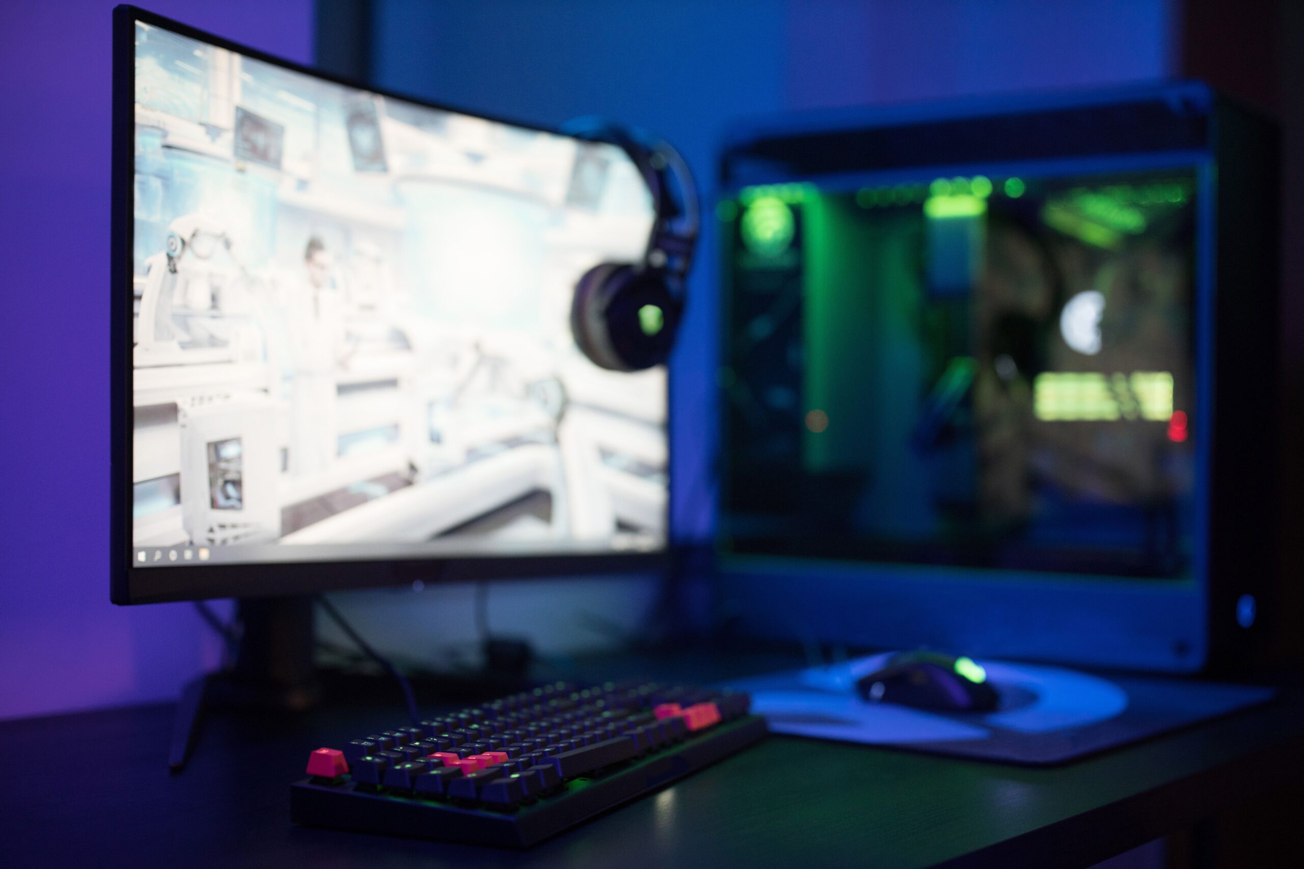 Configuración de gaming avanzada con monitor curvo e iluminación RGB para una experiencia inmersiva.