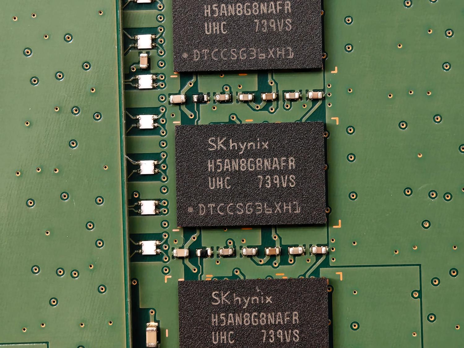 Primer plano detallado de chips de memoria DRAM de SK hynix sobre una placa de circuito verde, ilustrando los componentes físicos de la producción de memoria.