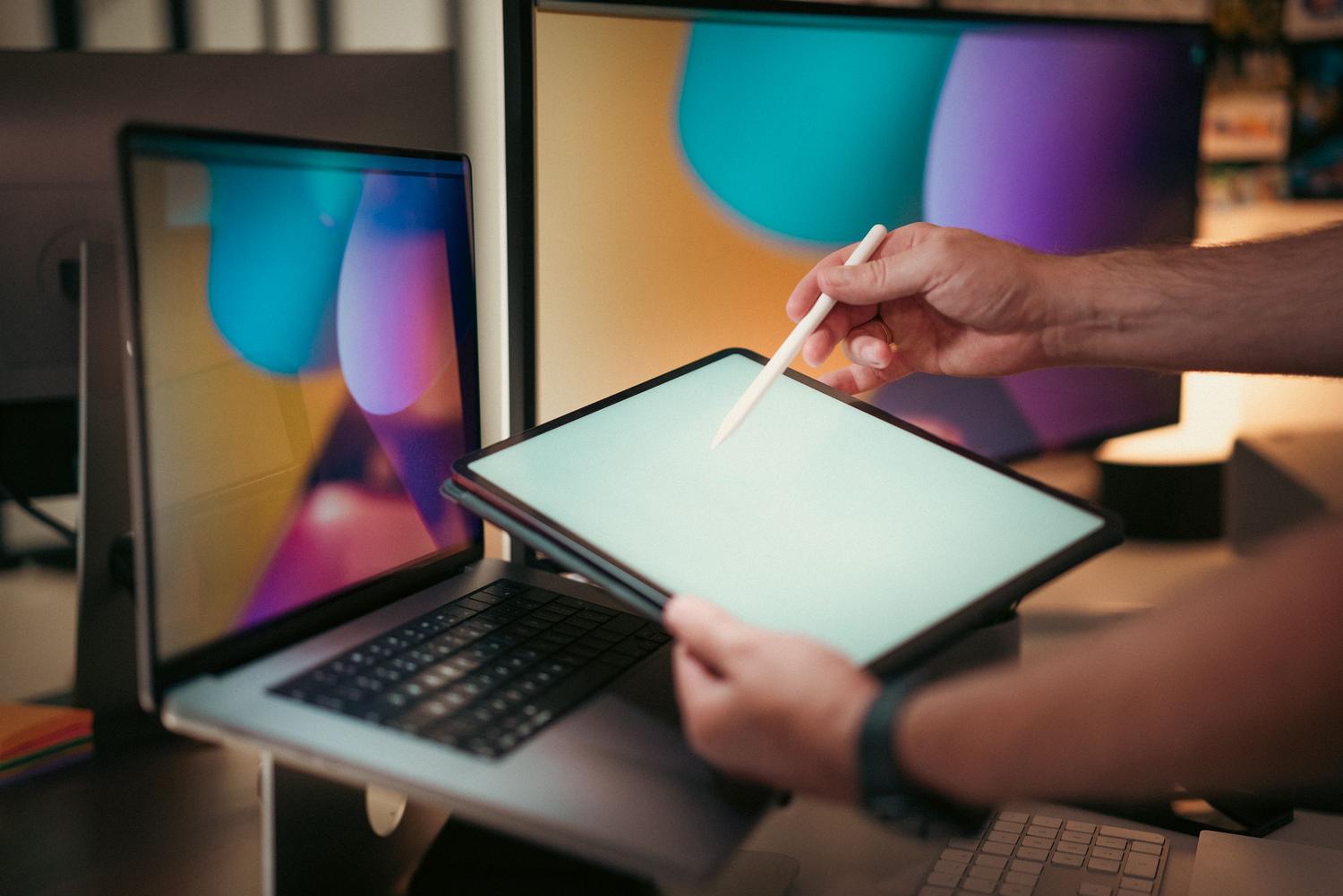Primer plano de un diseñador utilizando un lápiz óptico sobre una tablet en un espacio de trabajo moderno para diseño digital.