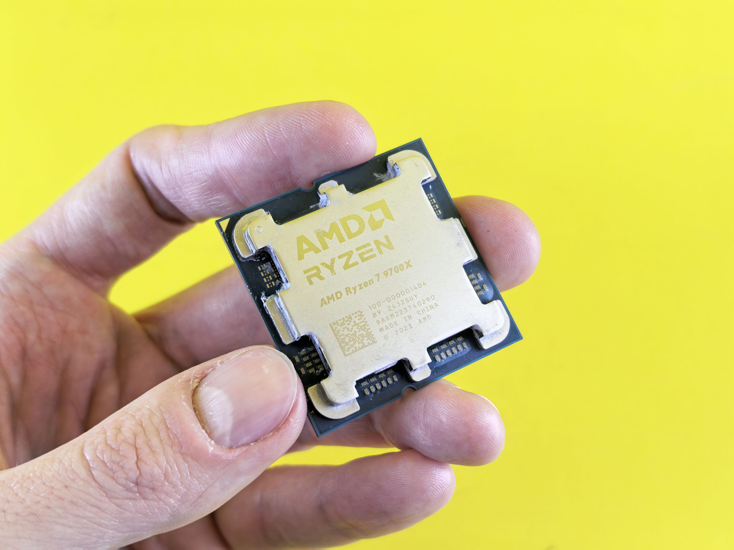 Detalle de un procesador AMD Ryzen sostenido en la mano, representando el núcleo del sistema