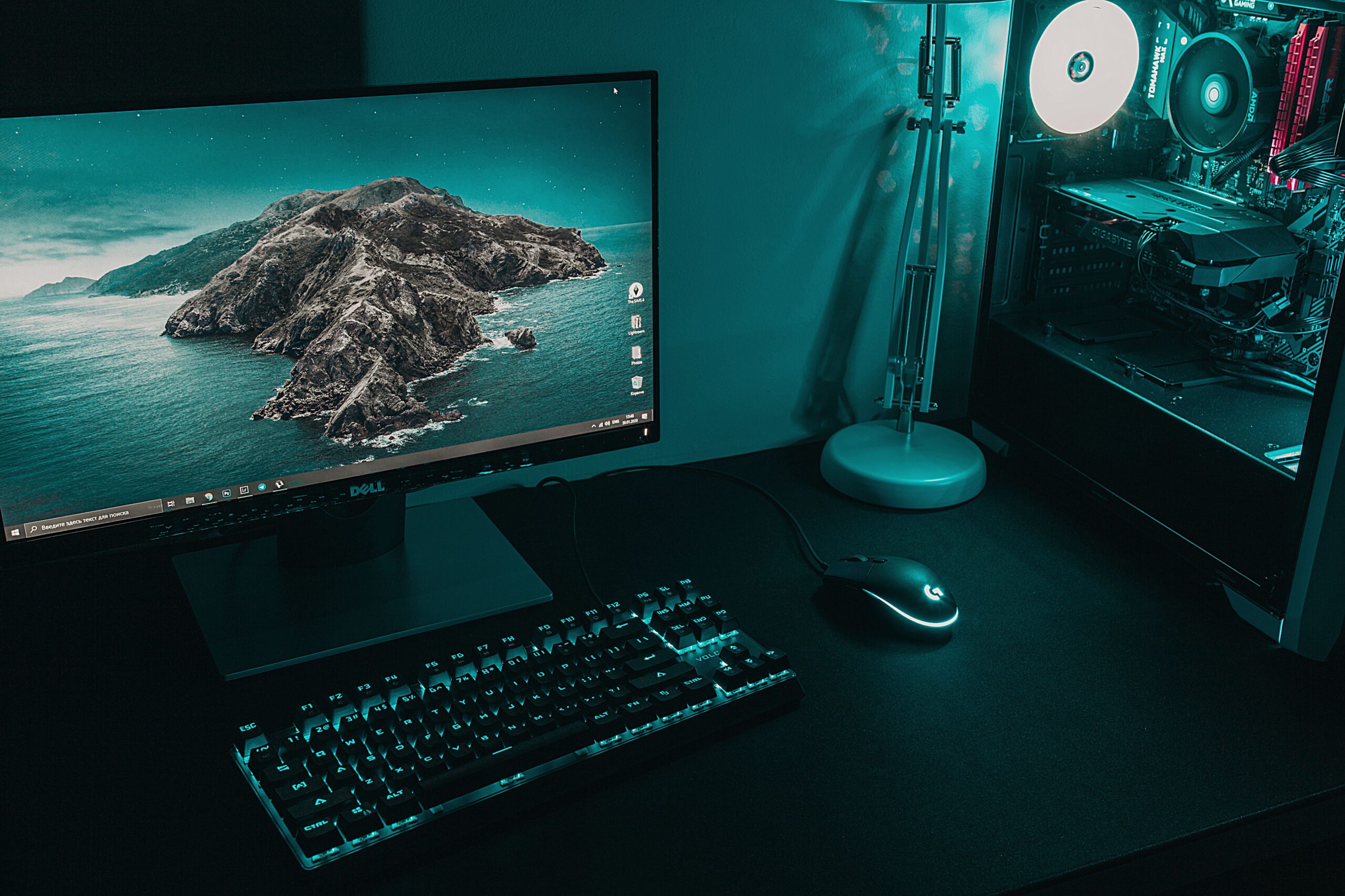 Setup completo de gaming con monitor, teclado y torre de PC en un entorno oscuro y moderno
