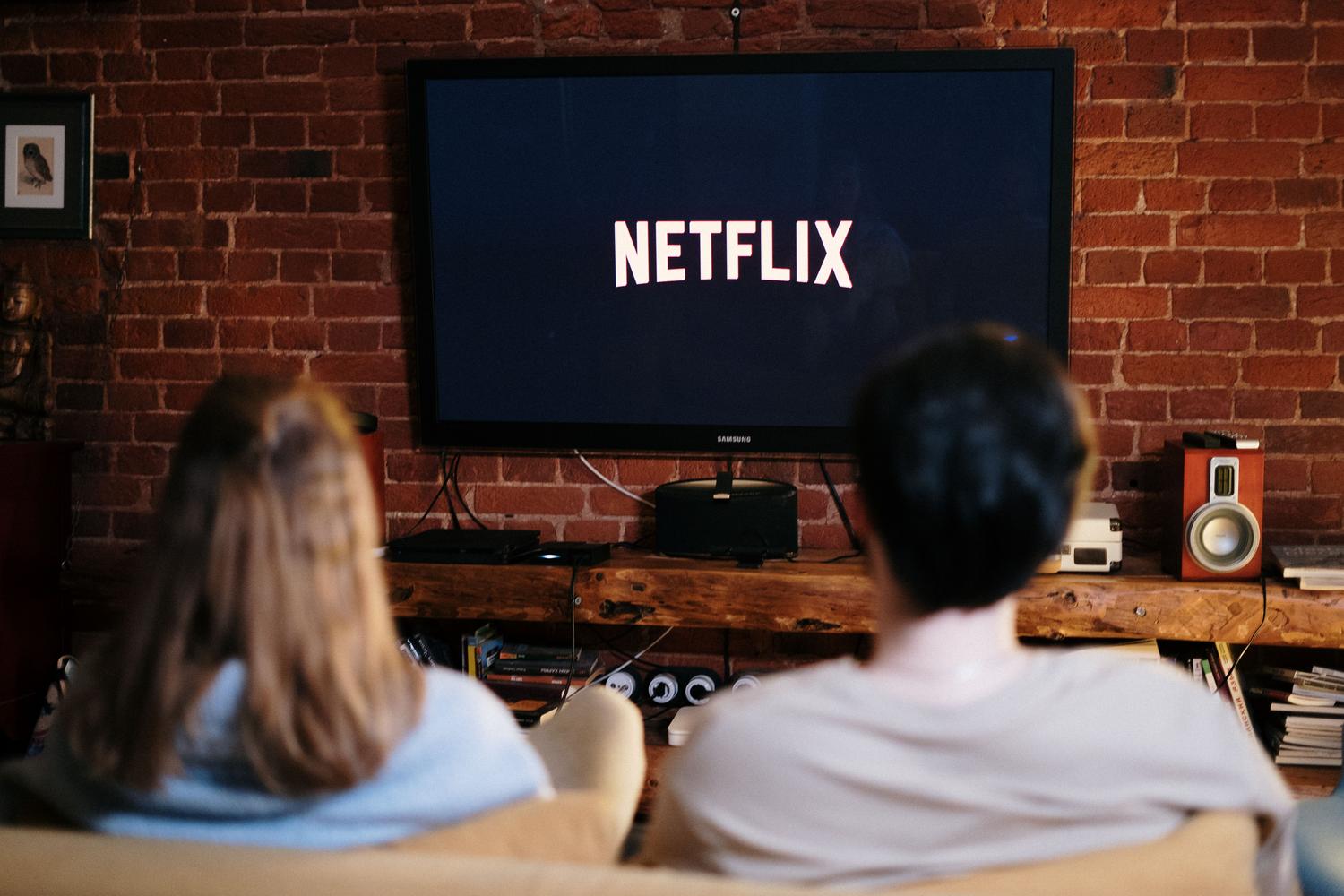 Pareja relajándose en el sofá mientras disfrutan de contenido audiovisual, representando el consumo final de los archivos organizados.
