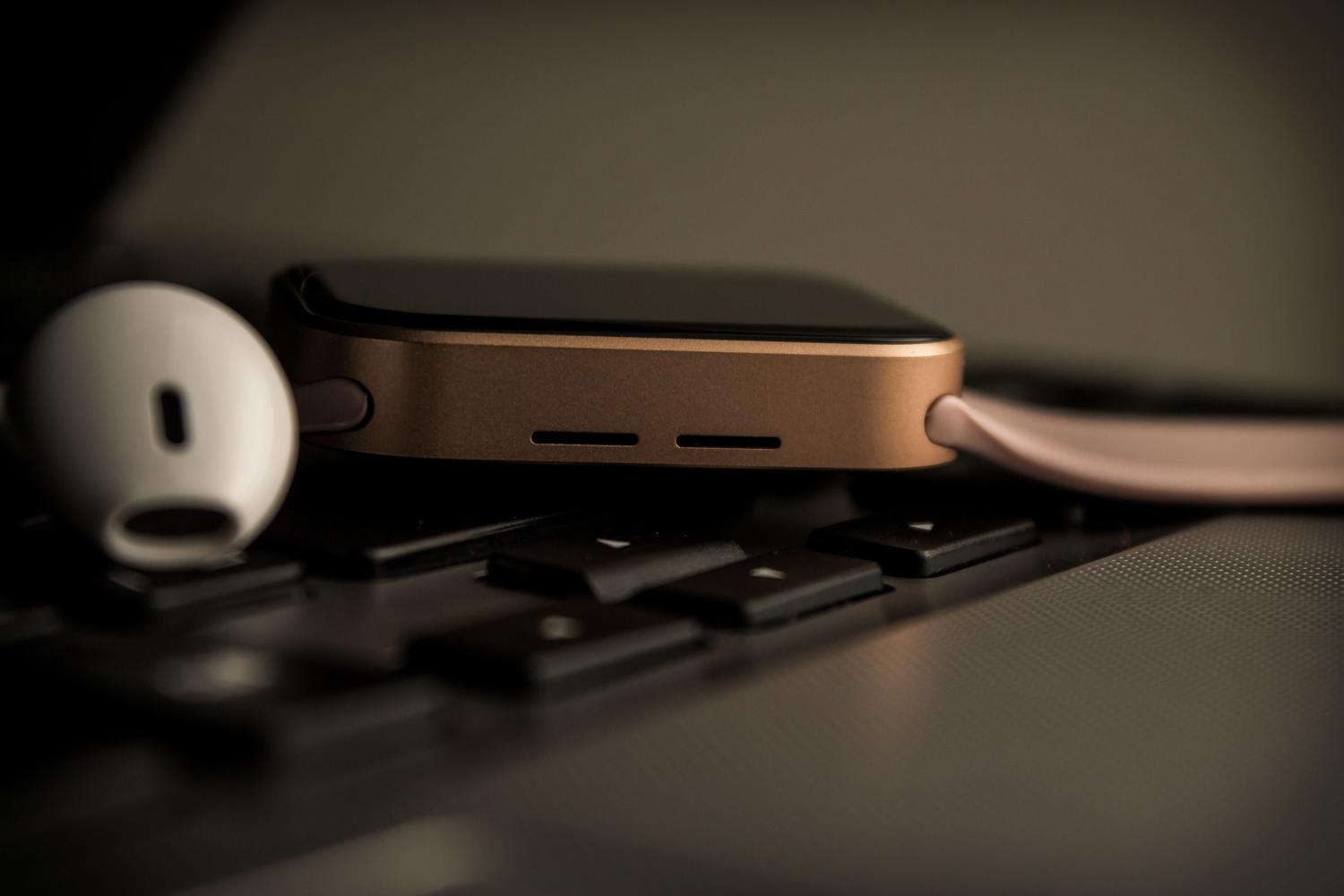 Ecosistema de dispositivos Apple con un Apple Watch y un portátil, representando la sincronización de archivos entre dispositivos.