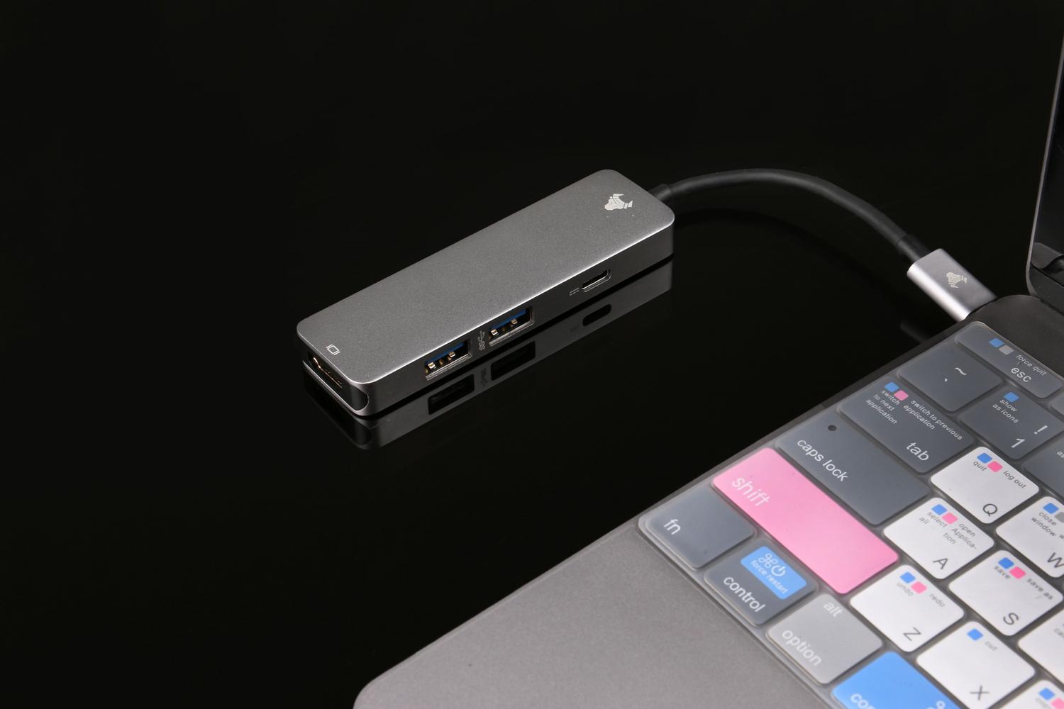 Hub USB conectado a un ordenador portátil para ampliar la conectividad de periféricos.