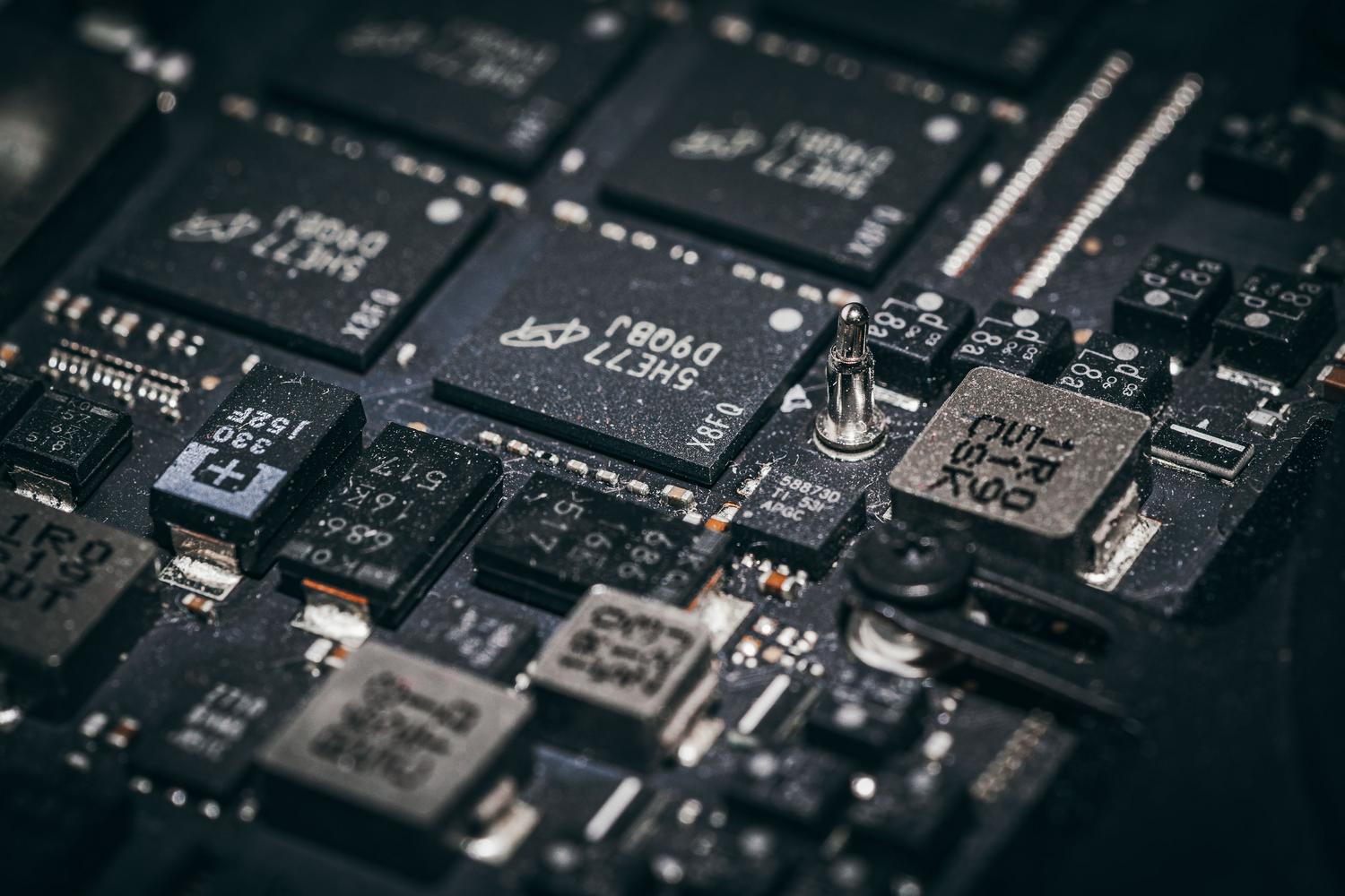 Detalle de microchips y circuitos electrónicos en una placa, representando la infraestructura física donde ocurren las vulnerabilidades.