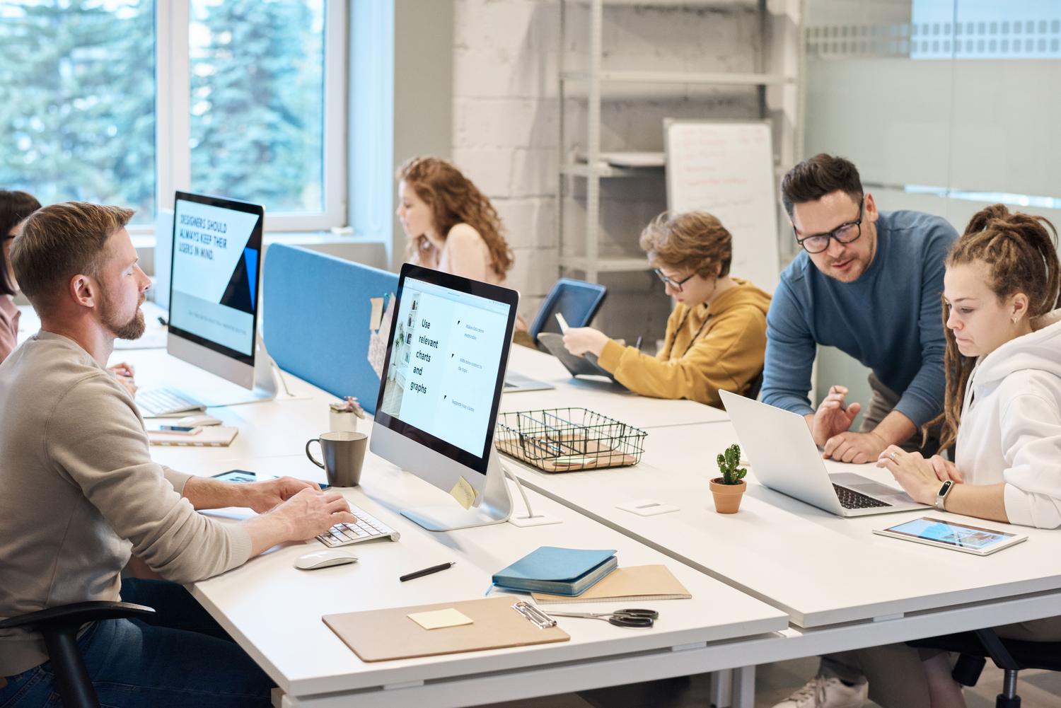 Equipo multidisciplinar colaborando en una oficina moderna, representando la creación de una cultura de seguridad corporativa basada en la cooperación.