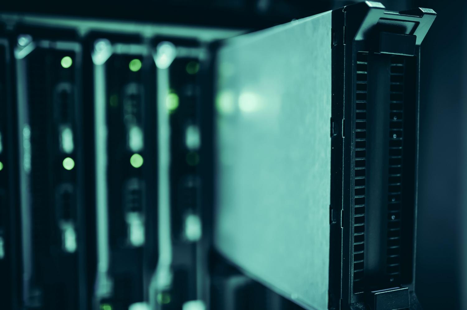 Primer plano de servidores en un rack con iluminación azul verdosa, simbolizando la potencia de cómputo y la infraestructura cloud.