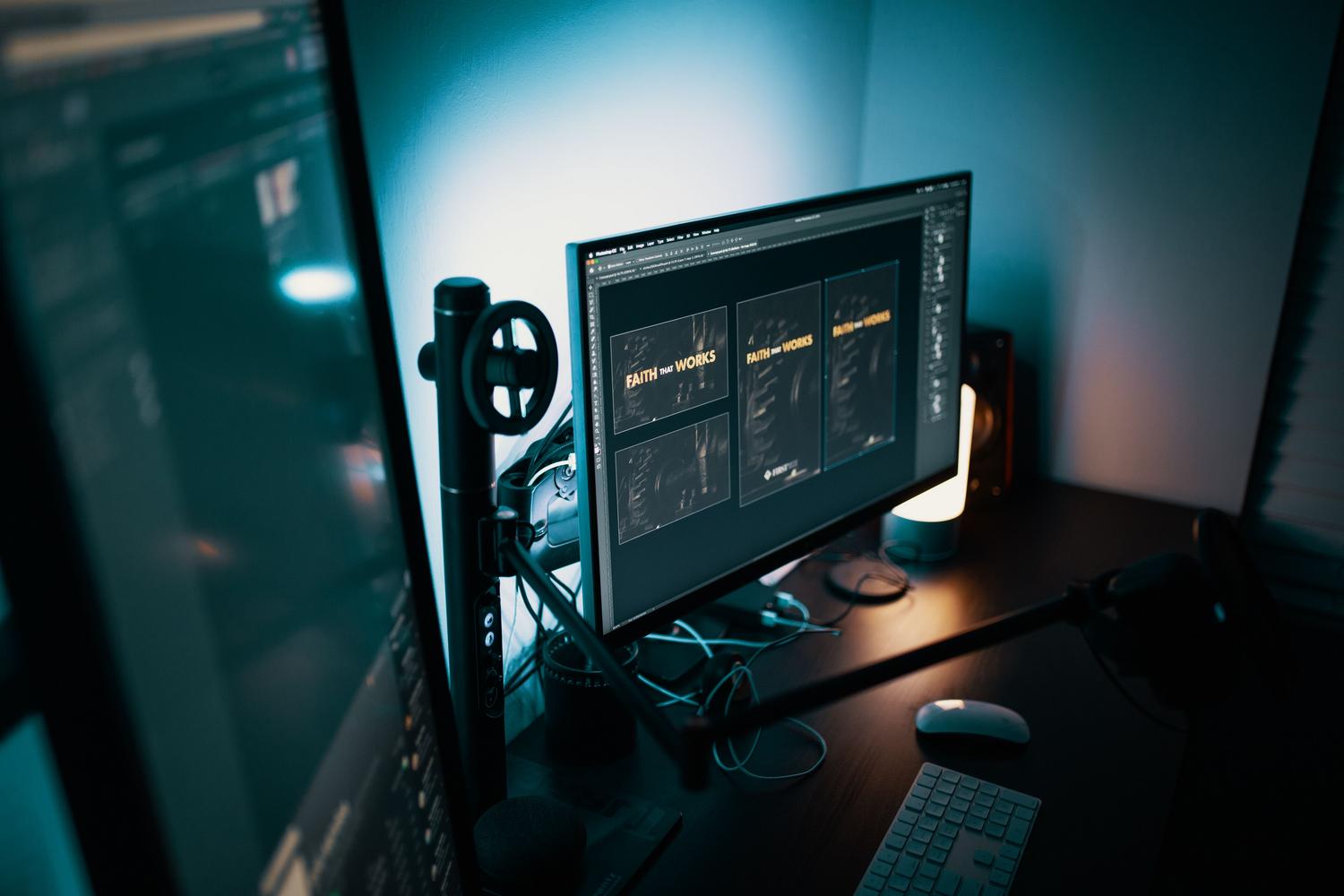 Estación de trabajo moderna con doble monitor en una habitación con poca luz, ideal para ilustrar la necesidad de controlar el brillo para evitar la fatiga ocular.