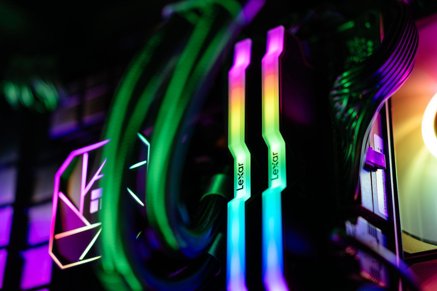 Primer plano de componentes de PC con iluminación RGB, destacando la memoria RAM y el sistema de refrigeración líquida.