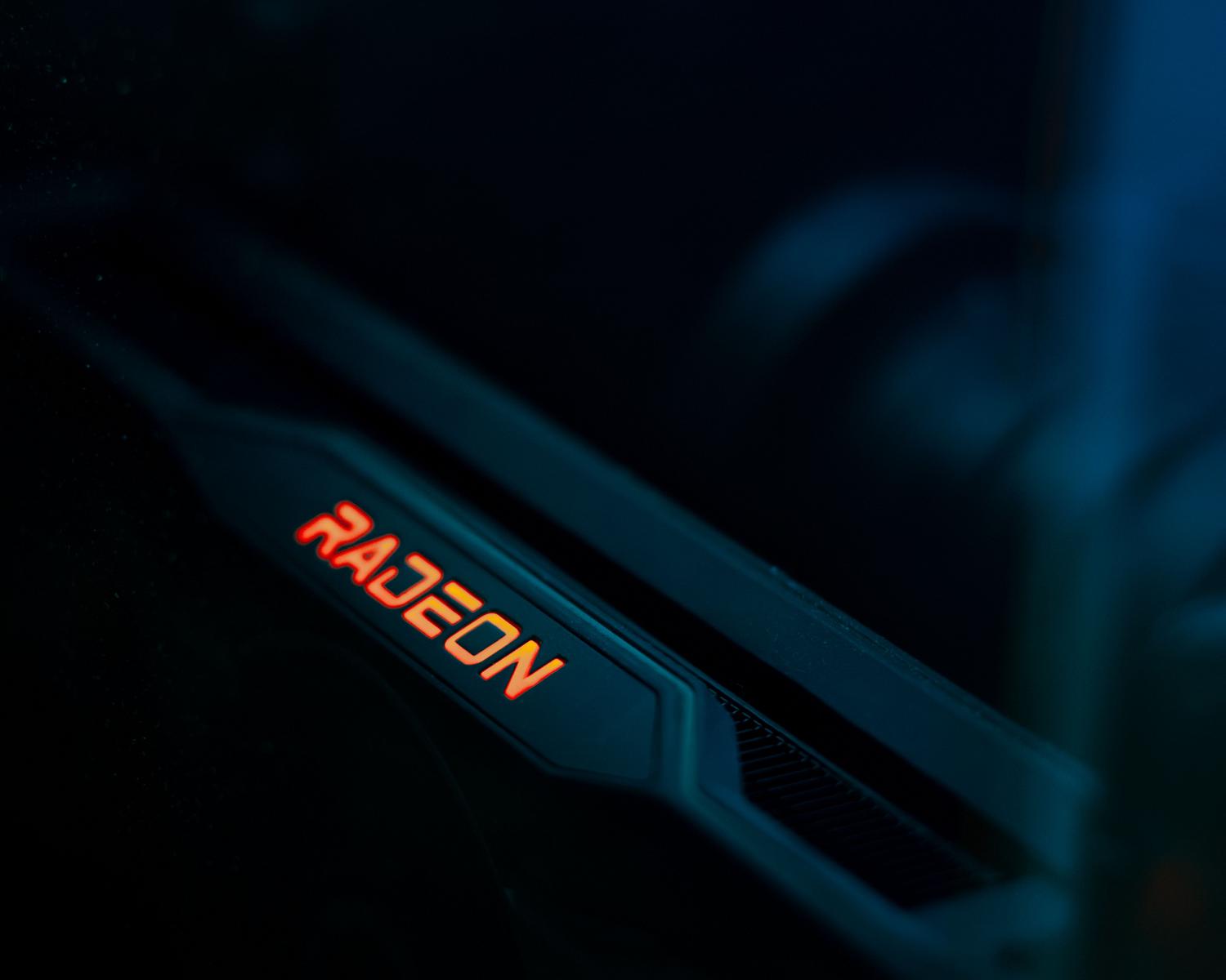 Detalle de una tarjeta gráfica AMD Radeon con iluminación azul y naranja, enfatizando la tecnología y potencia moderna.