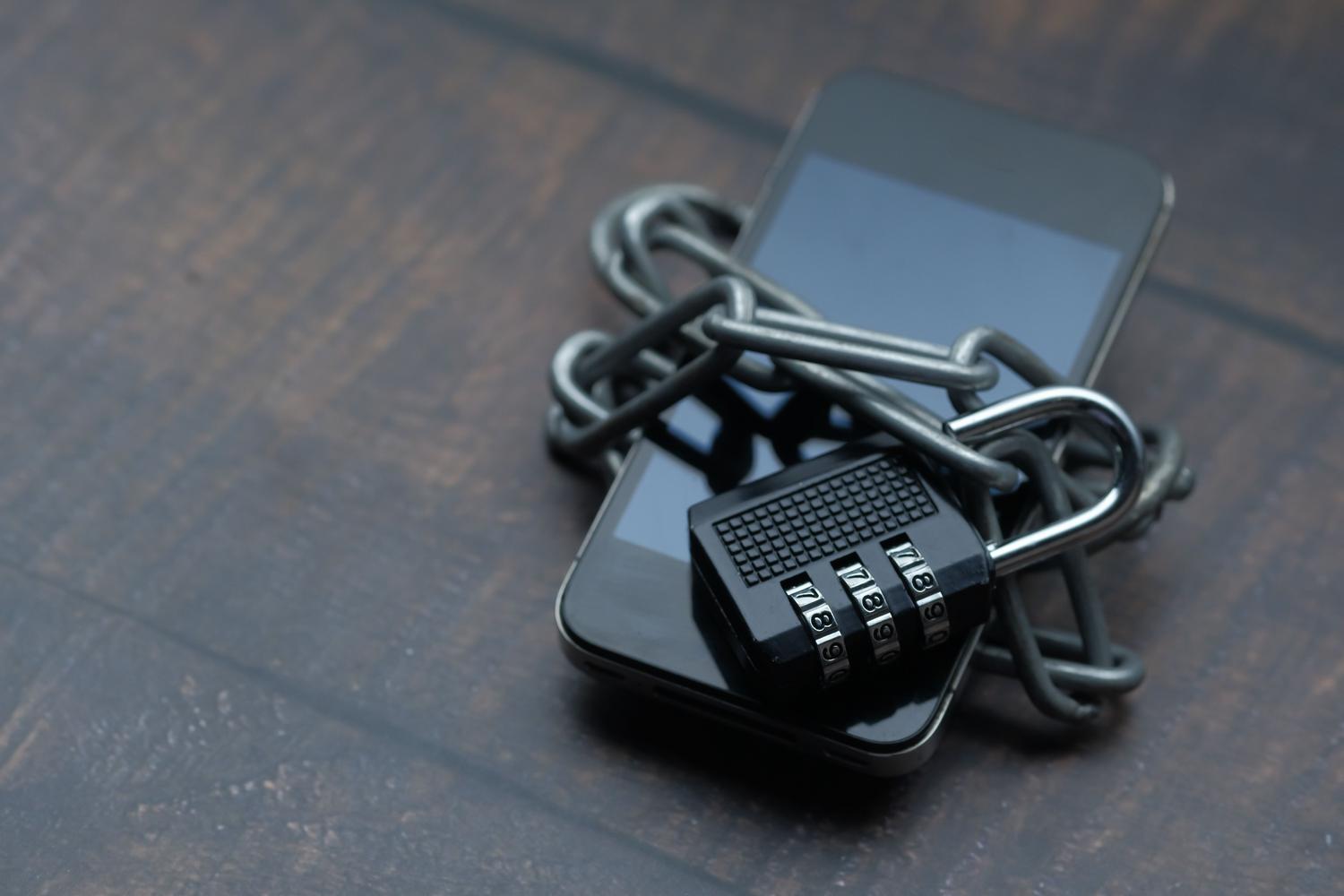 Smartphone bloqueado con una cadena y un candado, simbolizando la frustración de olvidar la contraseña.