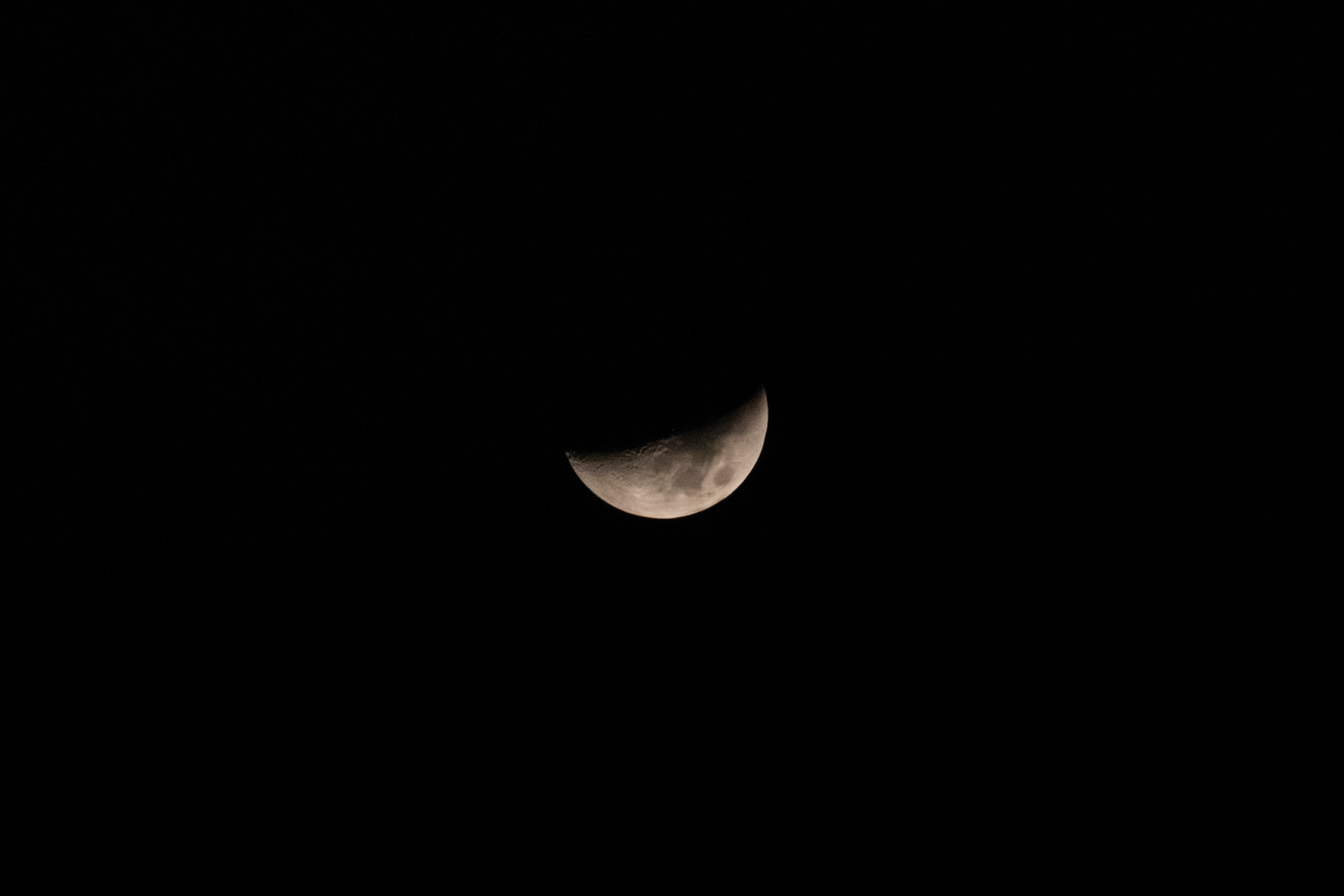 Imagen detallada de una luna creciente en un cielo nocturno despejado capturada con móvil.