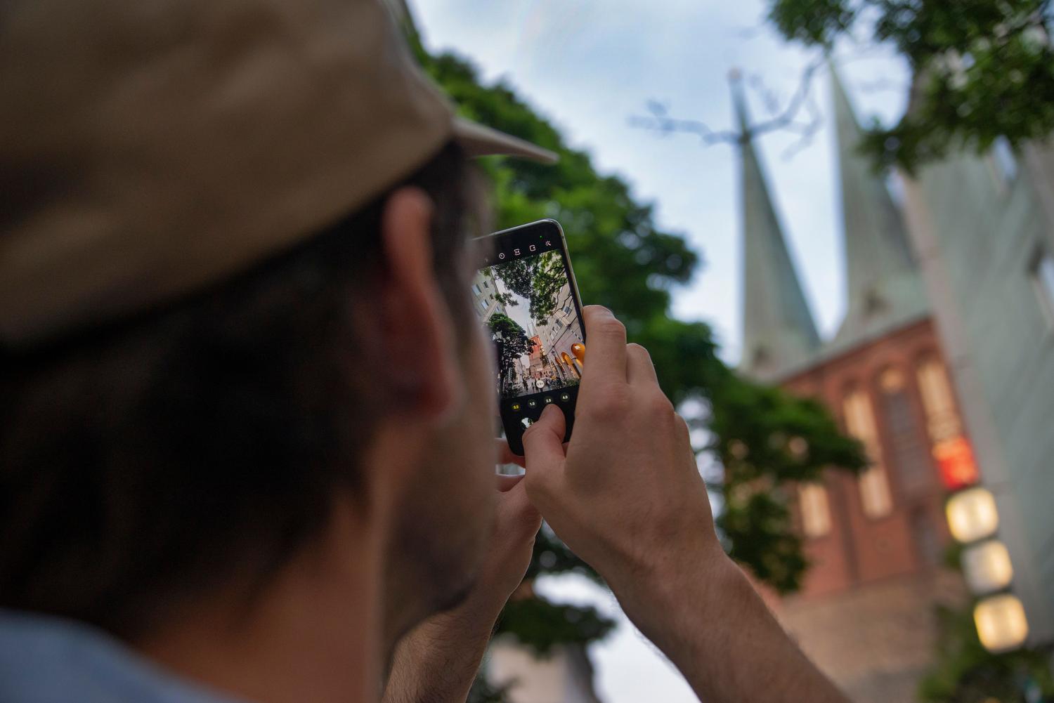 Persona capturando una escena urbana con un smartphone para ilustrar la toma de Live Photos.