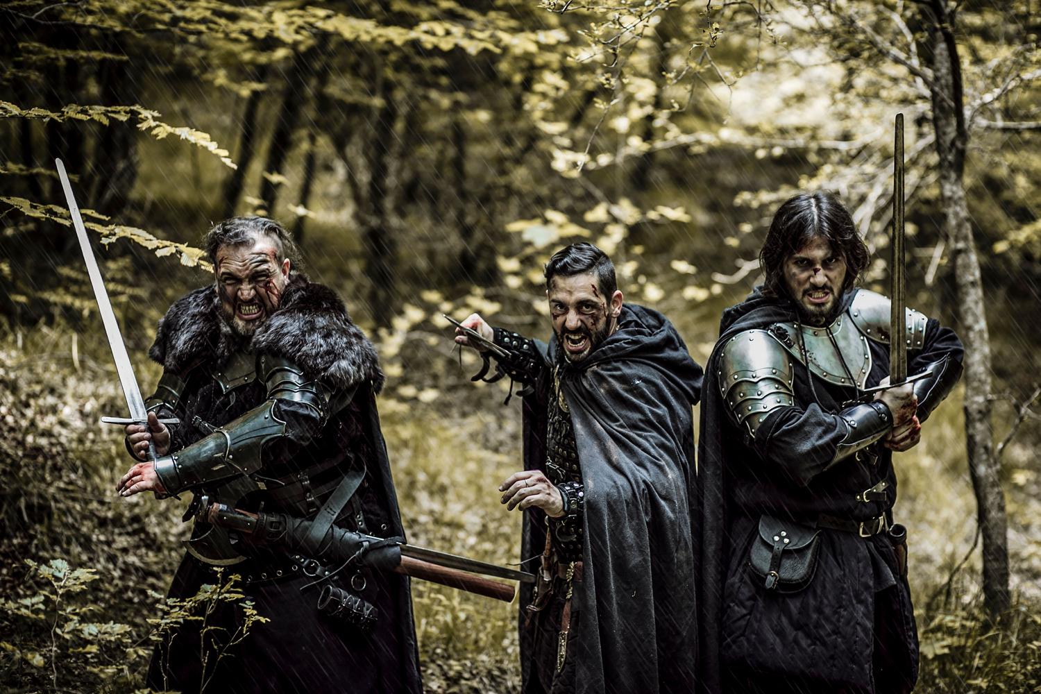 Grupo de guerreros con armaduras medievales en un bosque, evocando el plantel variado de luchadores.