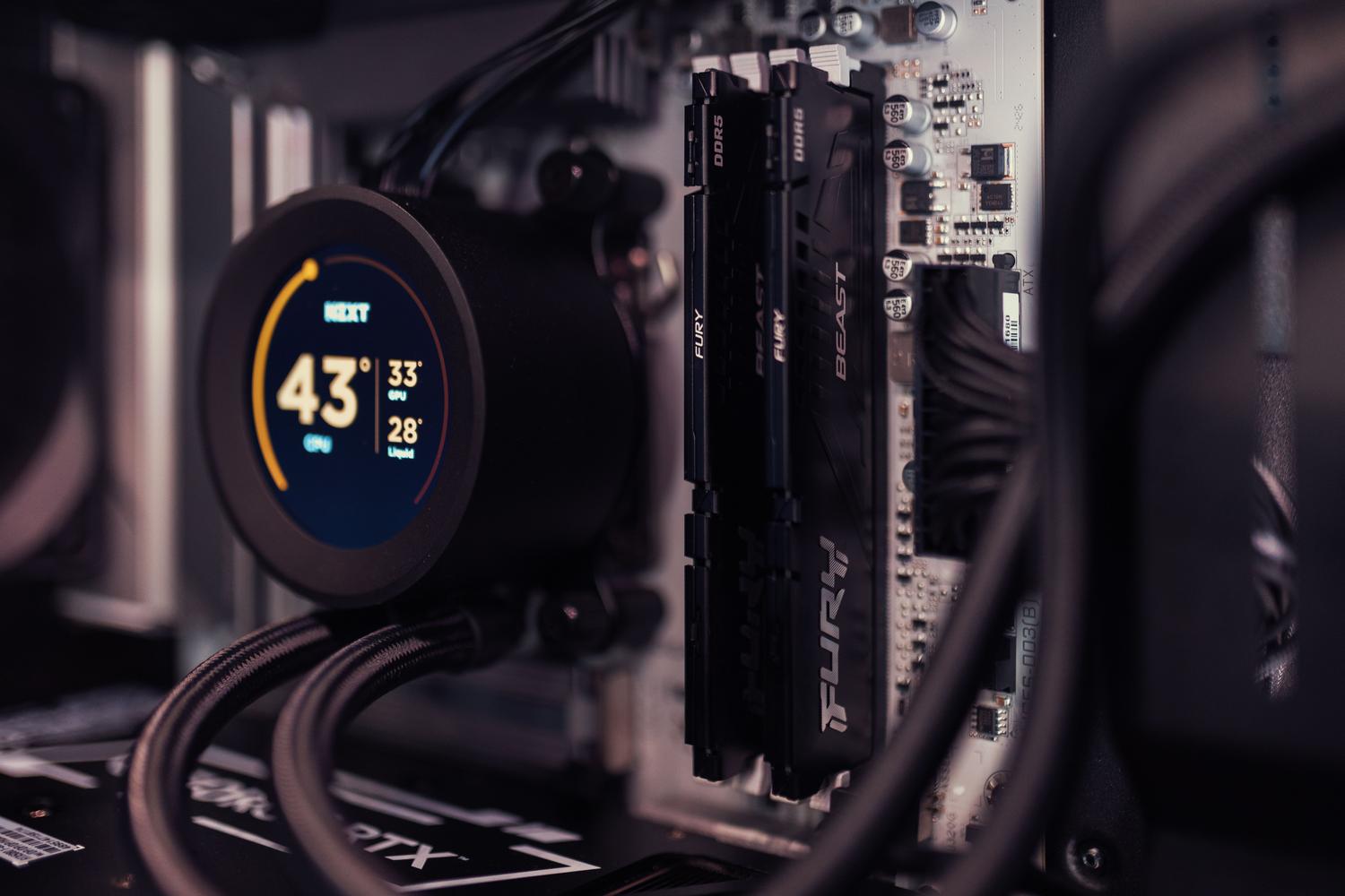 Interior de un PC gaming moderno con memorias DDR5 instaladas y sistema de refrigeración líquida