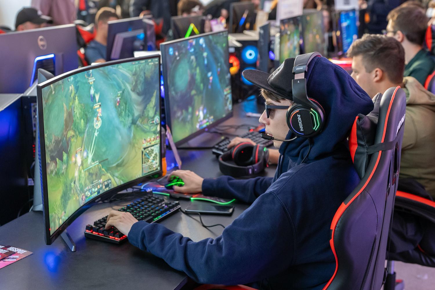 Jugadores profesionales en un torneo de eSports utilizando monitores curvos de alto rendimiento.