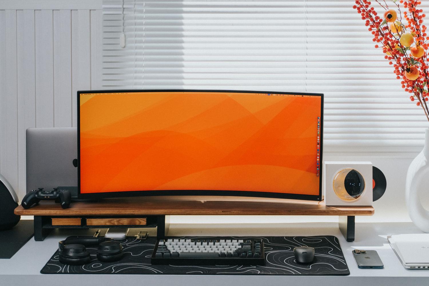 Escritorio minimalista y elegante con un monitor ultra ancho curvo, ideal para ilustrar resolución y tamaño de pantalla.