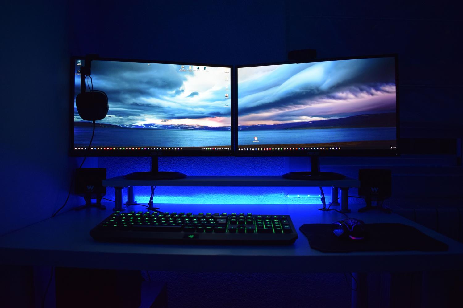 Gaming setup with dual monitors and atmospheric blue LED lighting, representing high-performance screens for gamers.
