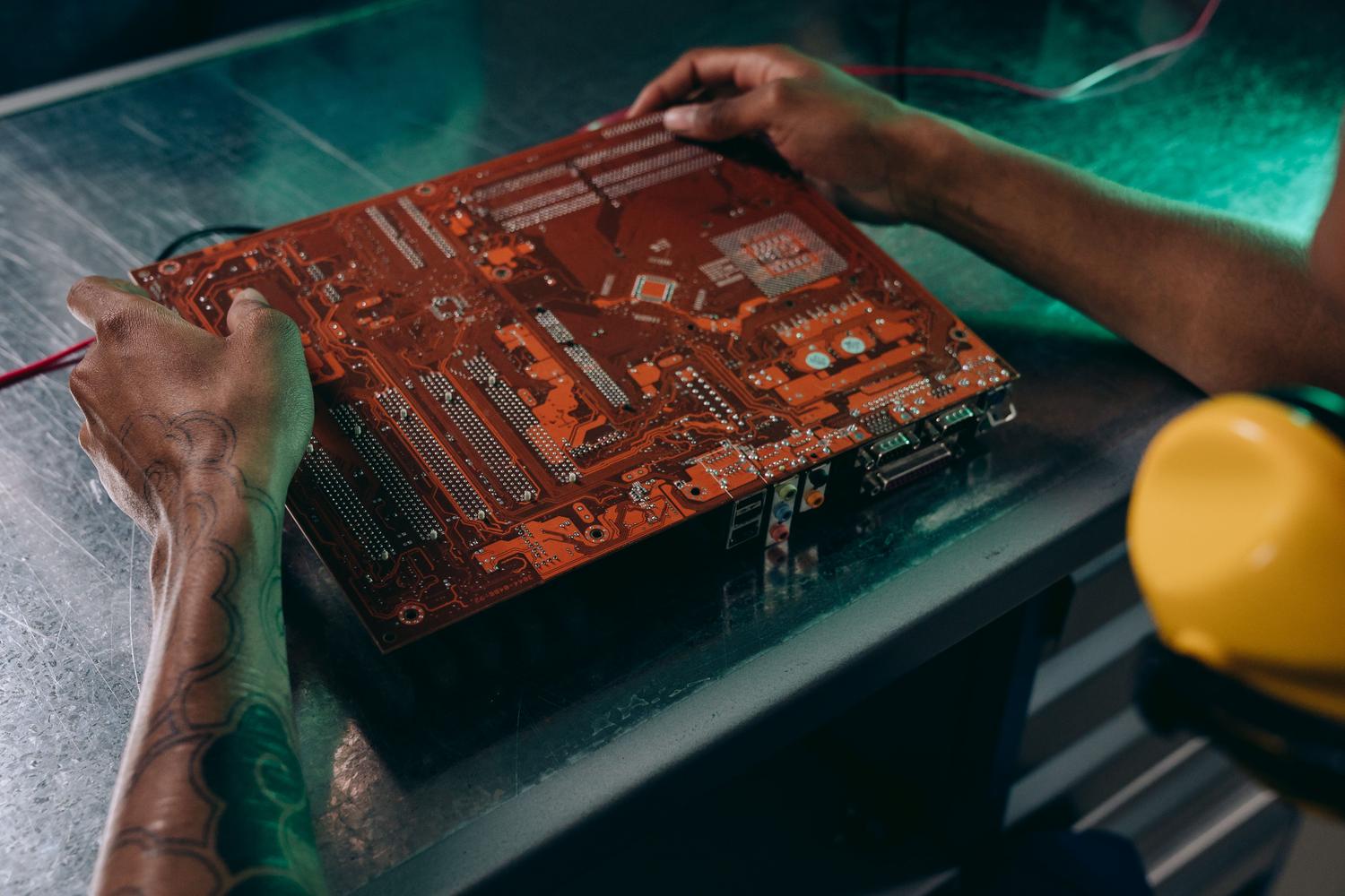 Técnico especializado trabajando en el ensamblaje de una placa base industrial para sistemas Edge.