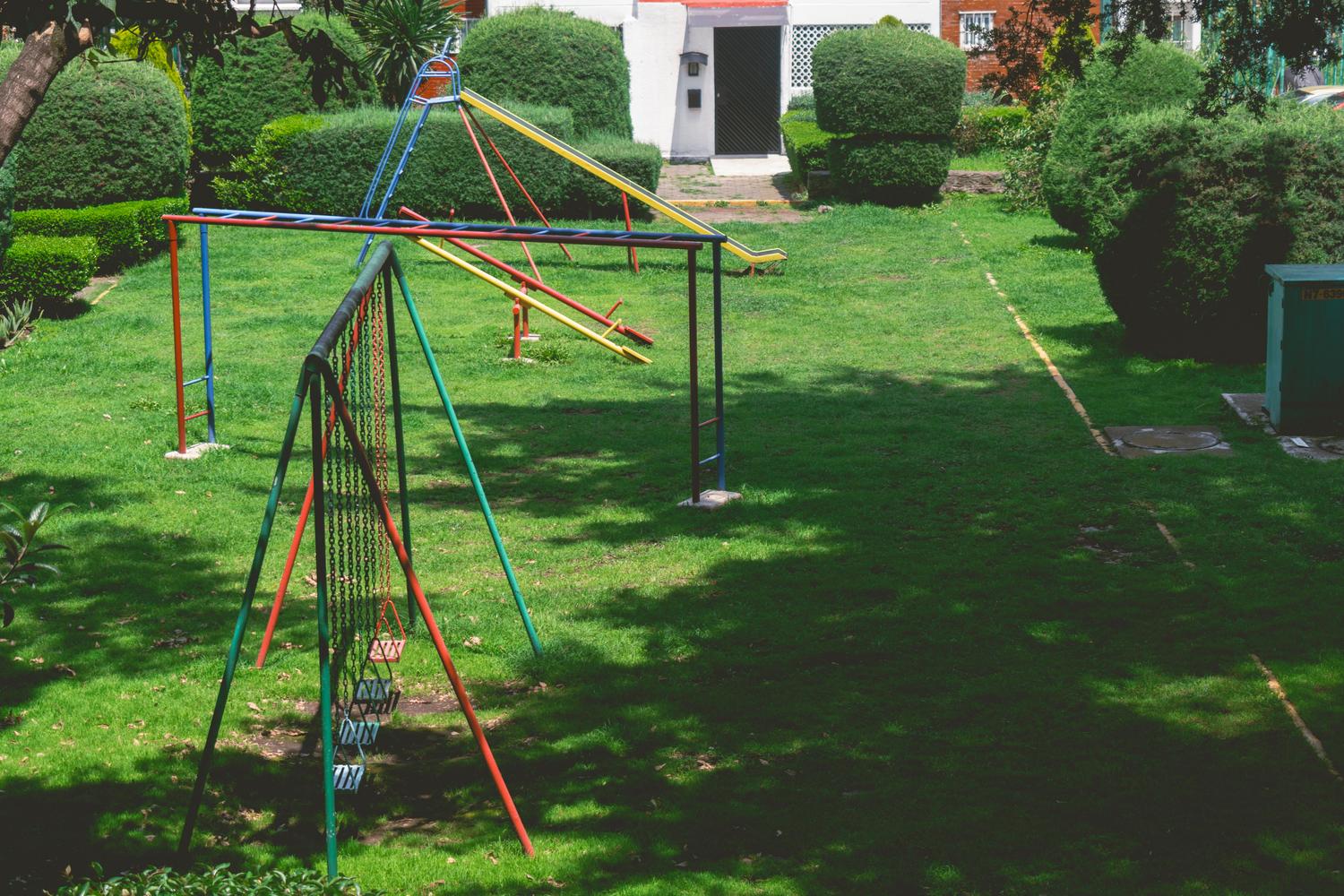 Parque infantil soleado y vacío, sirviendo como contraste visual para resaltar la importancia del equilibrio entre la vida digital y la actividad física.