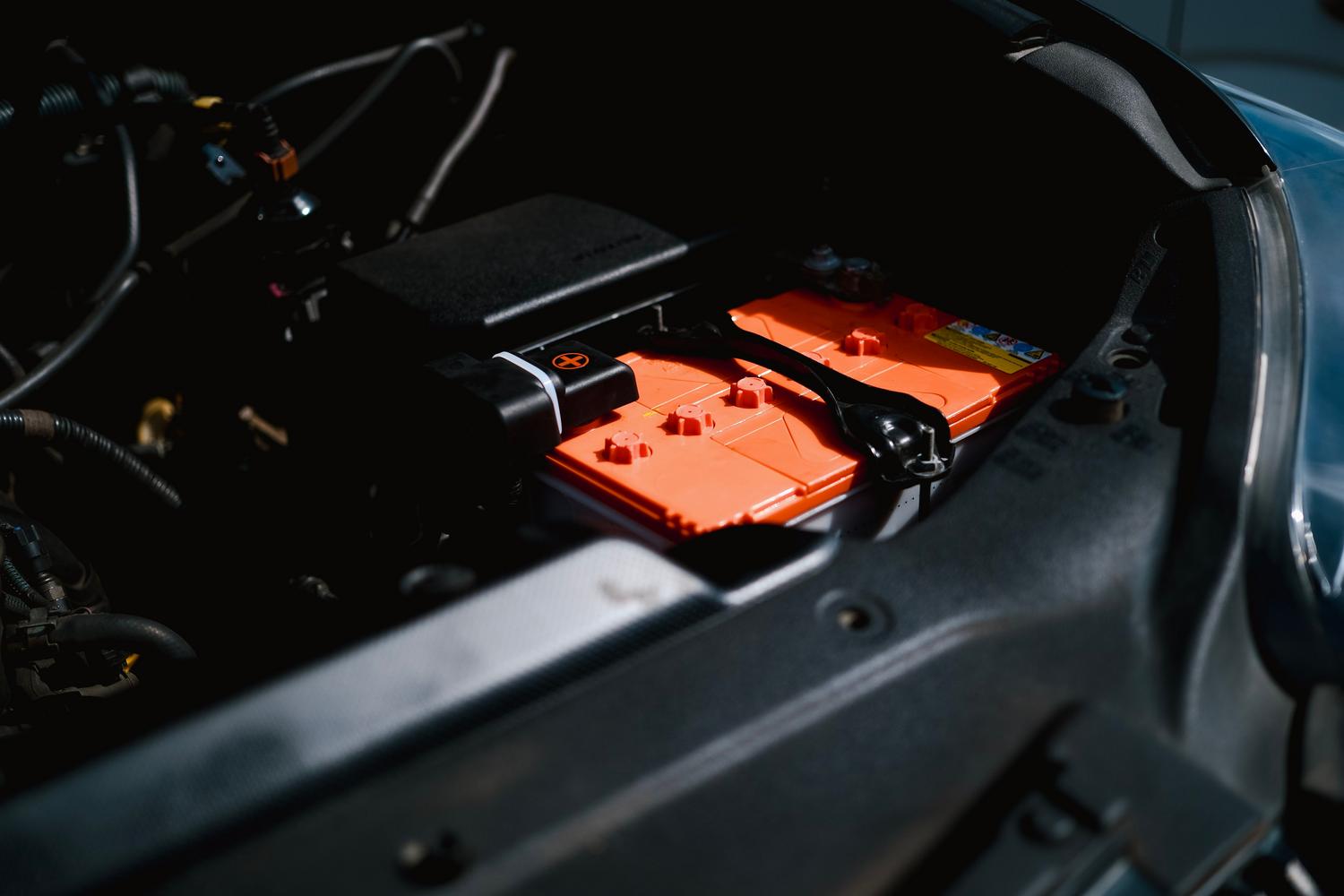 Detalle técnico de un paquete de baterías de litio en el compartimento de un vehículo eléctrico.