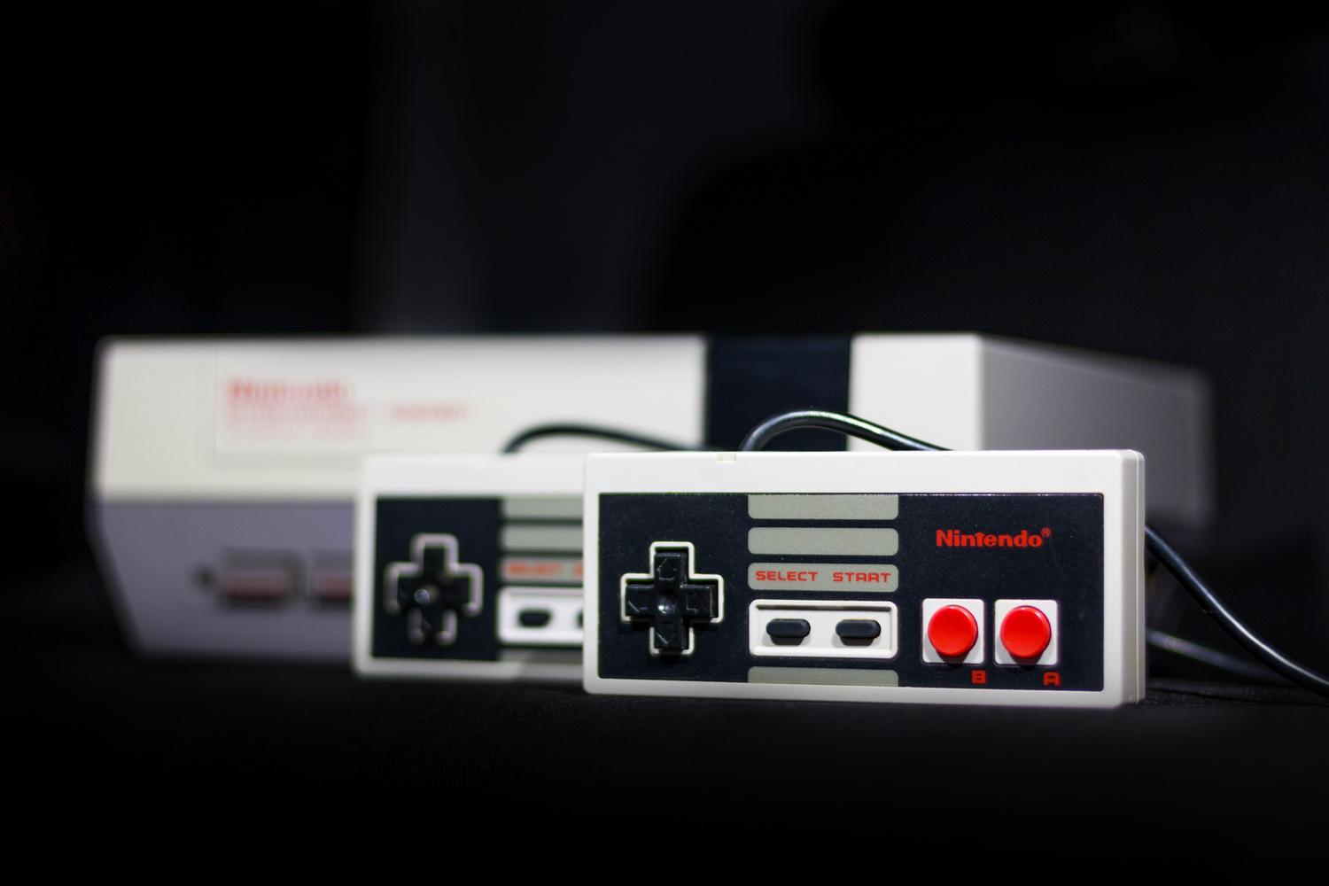 Primer plano de una consola Nintendo NES y sus mandos, representando el inicio de la era de las consolas domésticas.