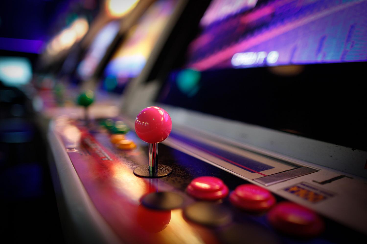Detalle de una máquina arcade vintage con joystick y botones iluminados, evocando la cultura de los salones recreativos.