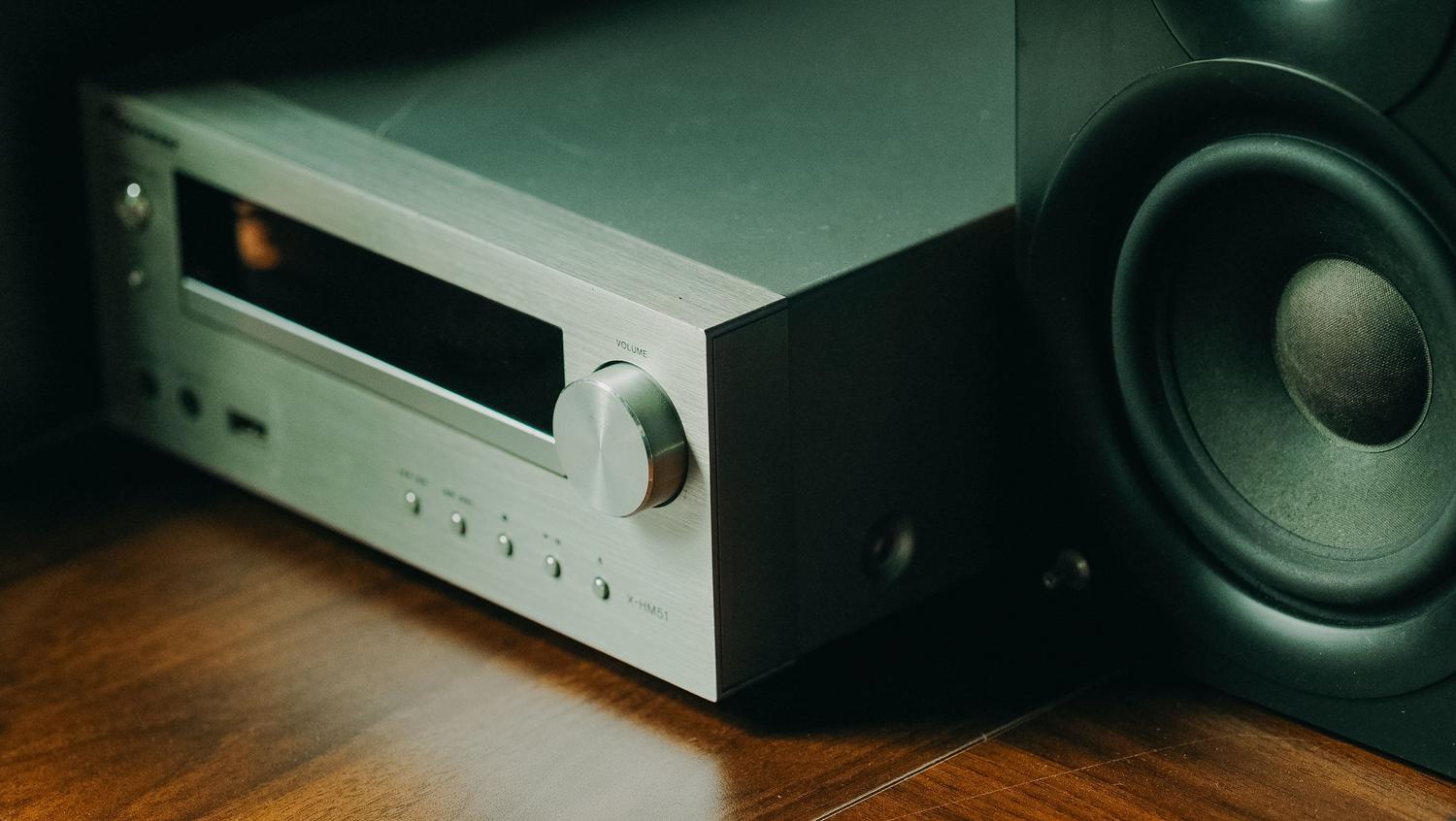 Detalle de un receptor de audio de alta gama con panel de aluminio cepillado y perilla de volumen.
