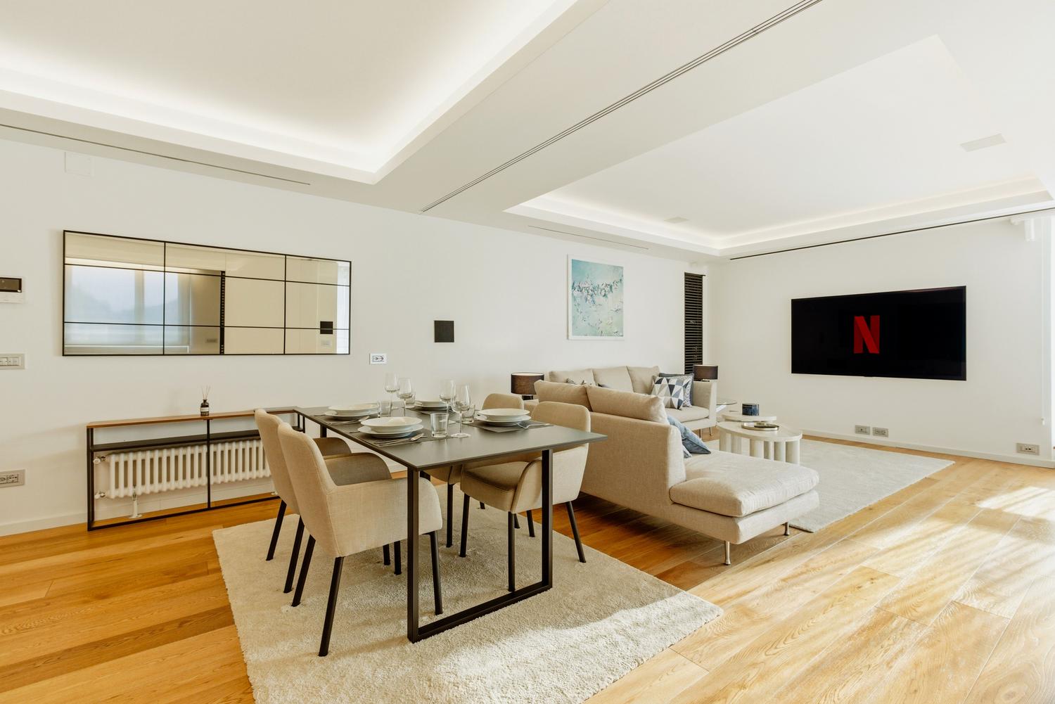 Salón moderno y luminoso con un televisor de pantalla plana mostrando una interfaz de streaming, ideal para ilustrar la configuración de Smart TVs.