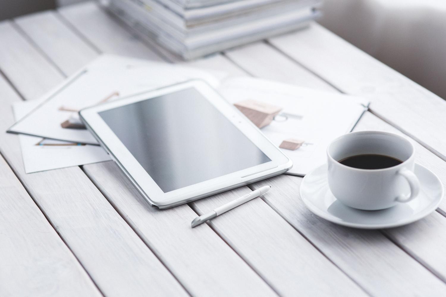 Tablet en un escritorio moderno junto a un café, representando el uso de la pantalla OLED para productividad y trabajo