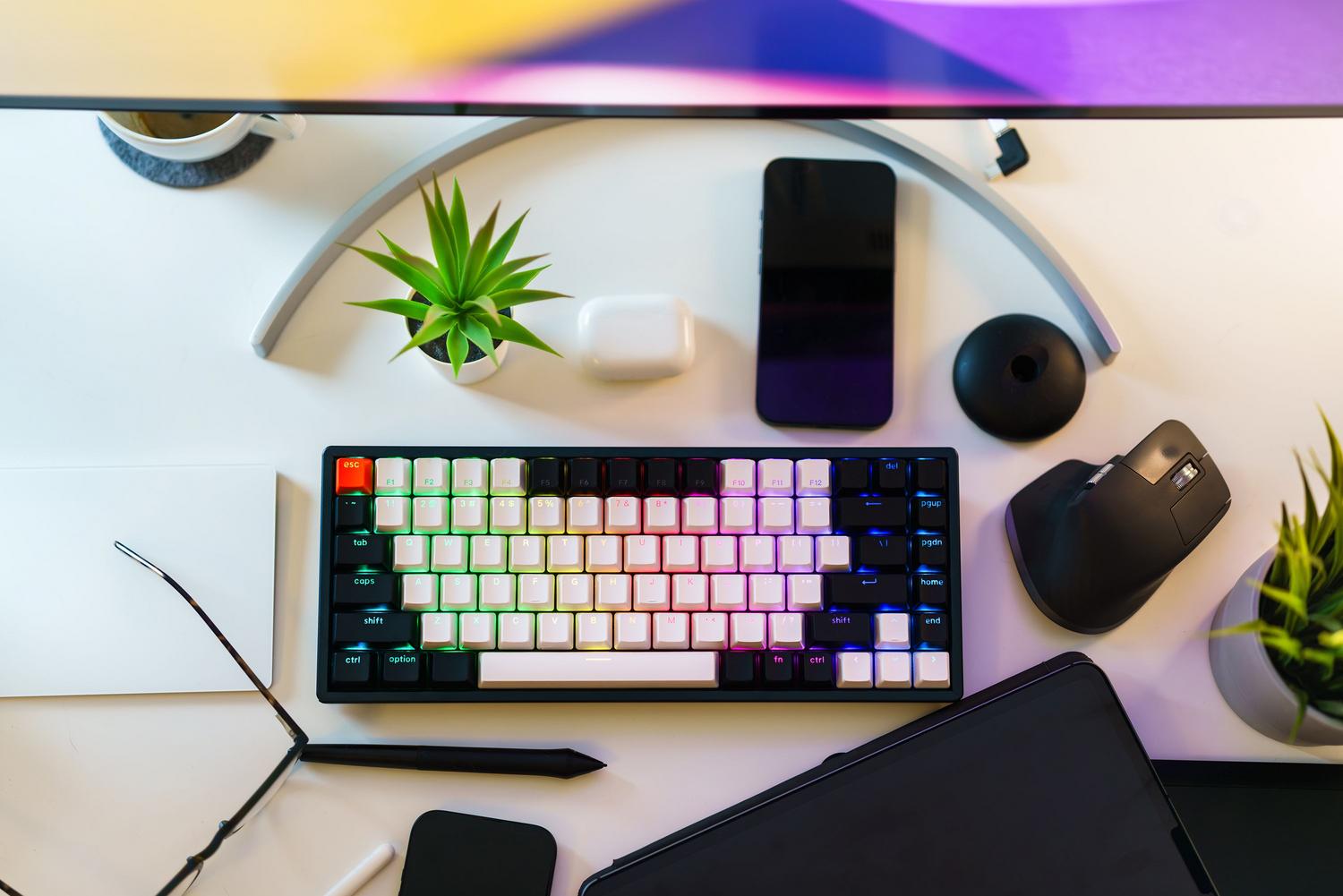 Escritorio de trabajo organizado con teclado, smartphone y elementos naturales para mejorar la productividad.