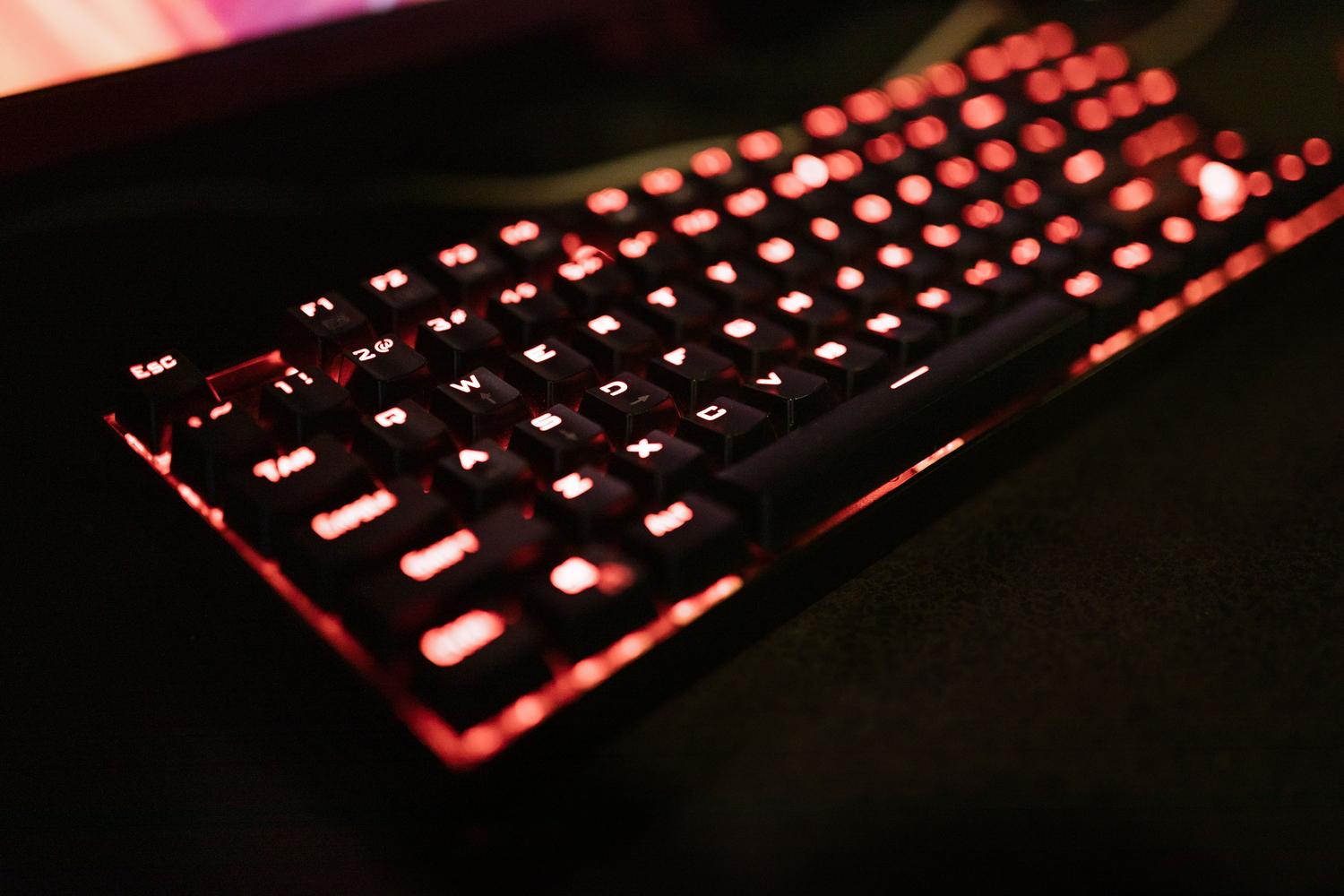 Detalle de un teclado mecánico con retroiluminación LED roja, destacando el diseño robusto para entusiastas del gaming.